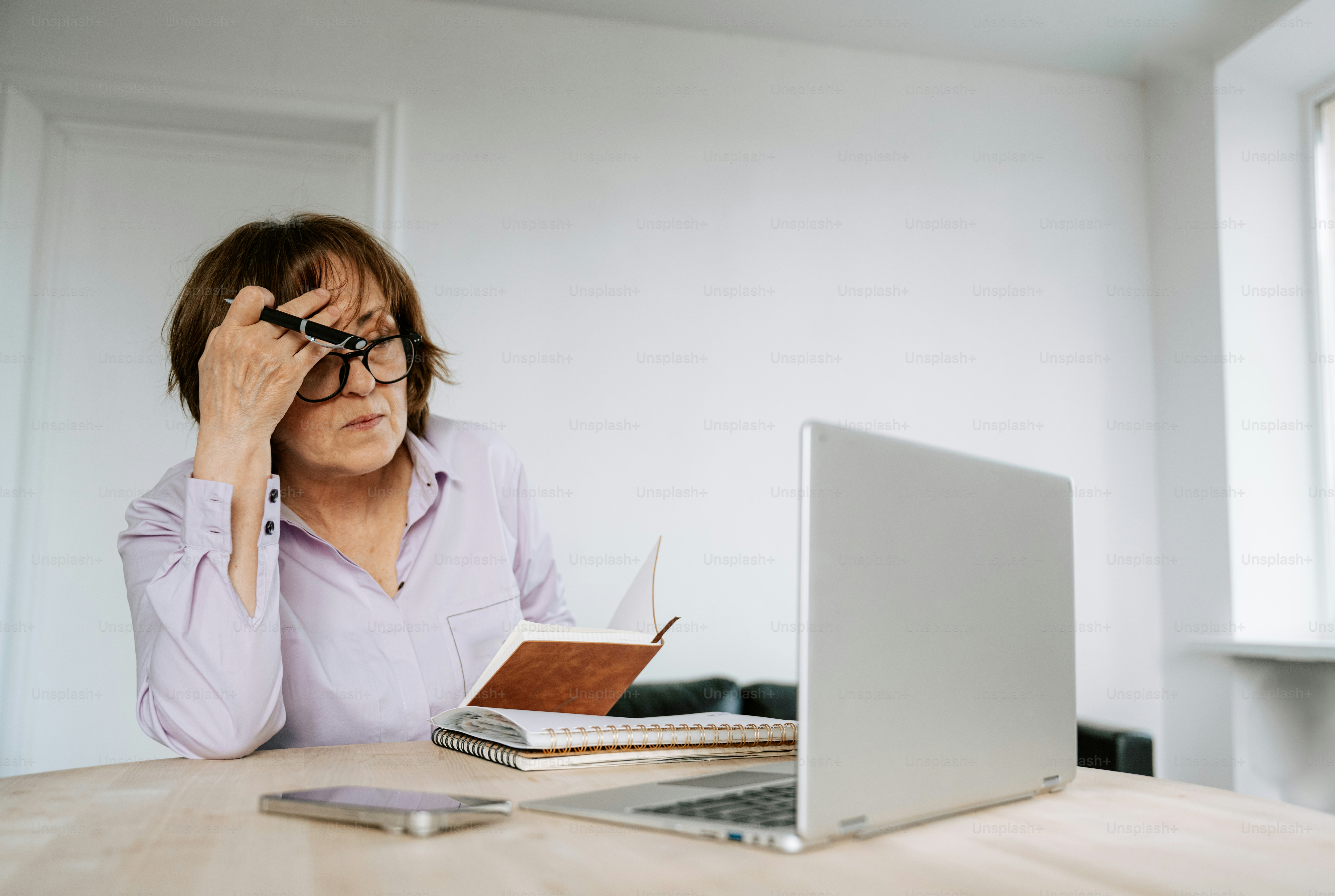 Woman appears stressed while working at a desk.