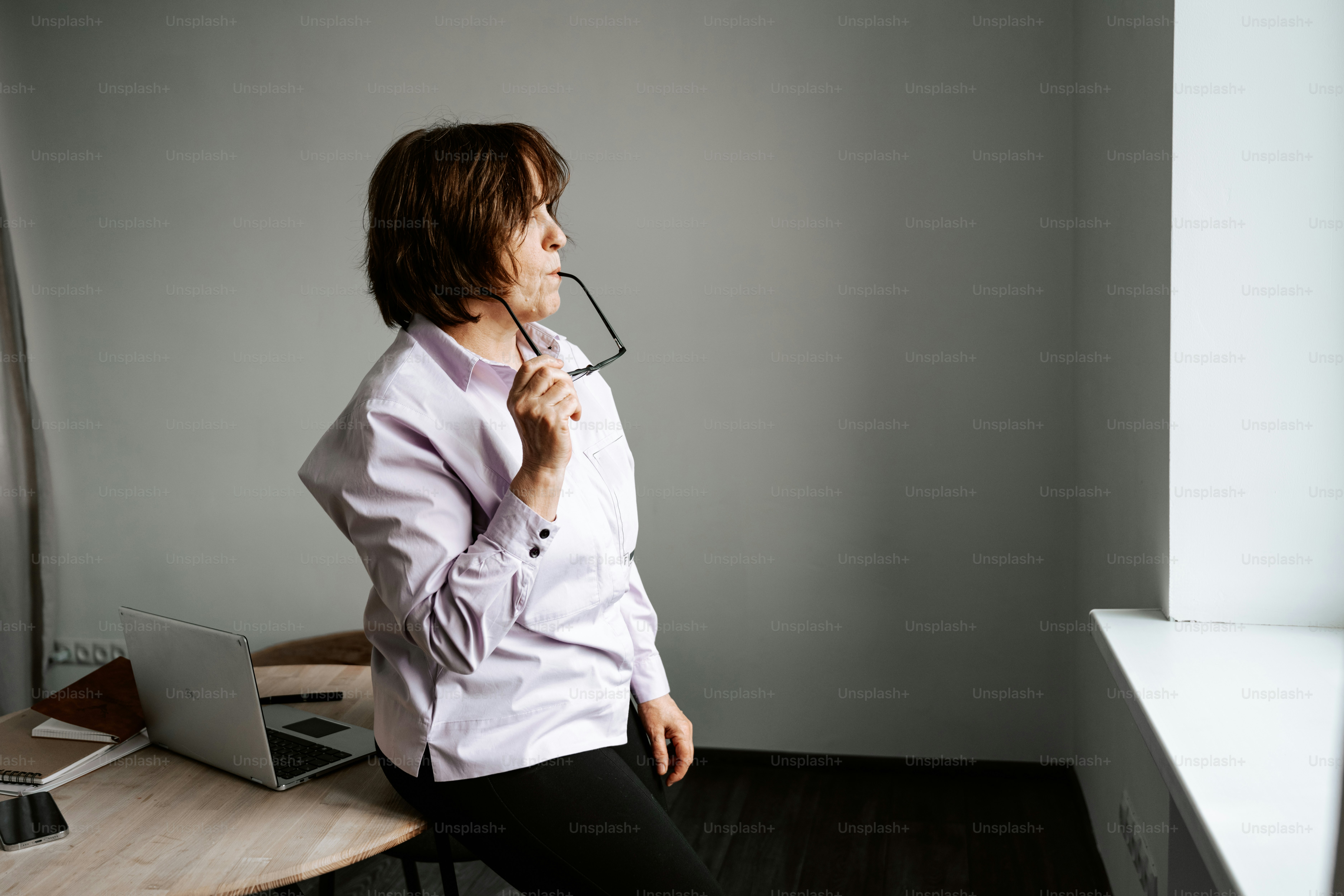 Die Frau hält inne und schaut aus dem Fenster.