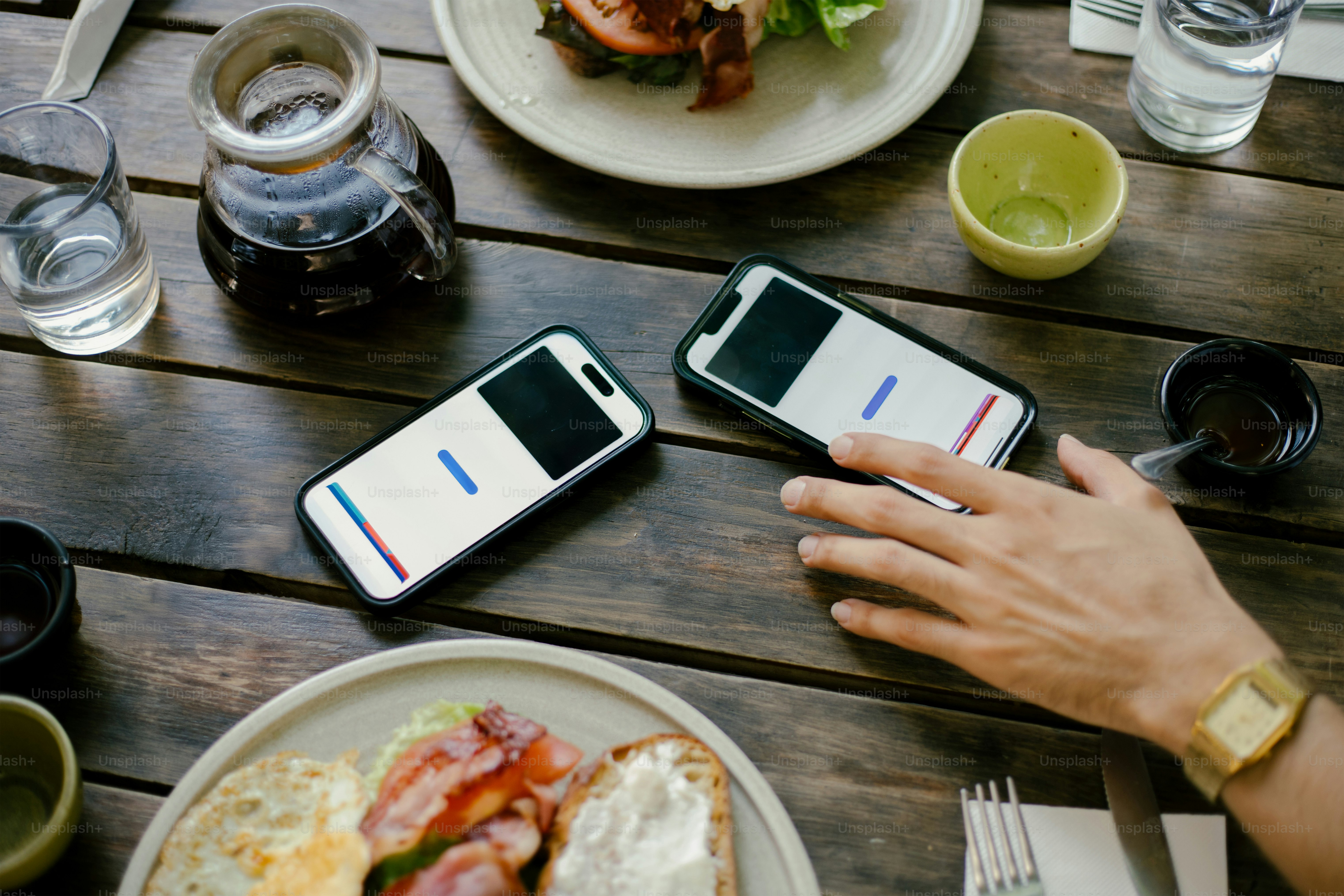 Two phones on a table with food. photo – Money Image on Unsplash