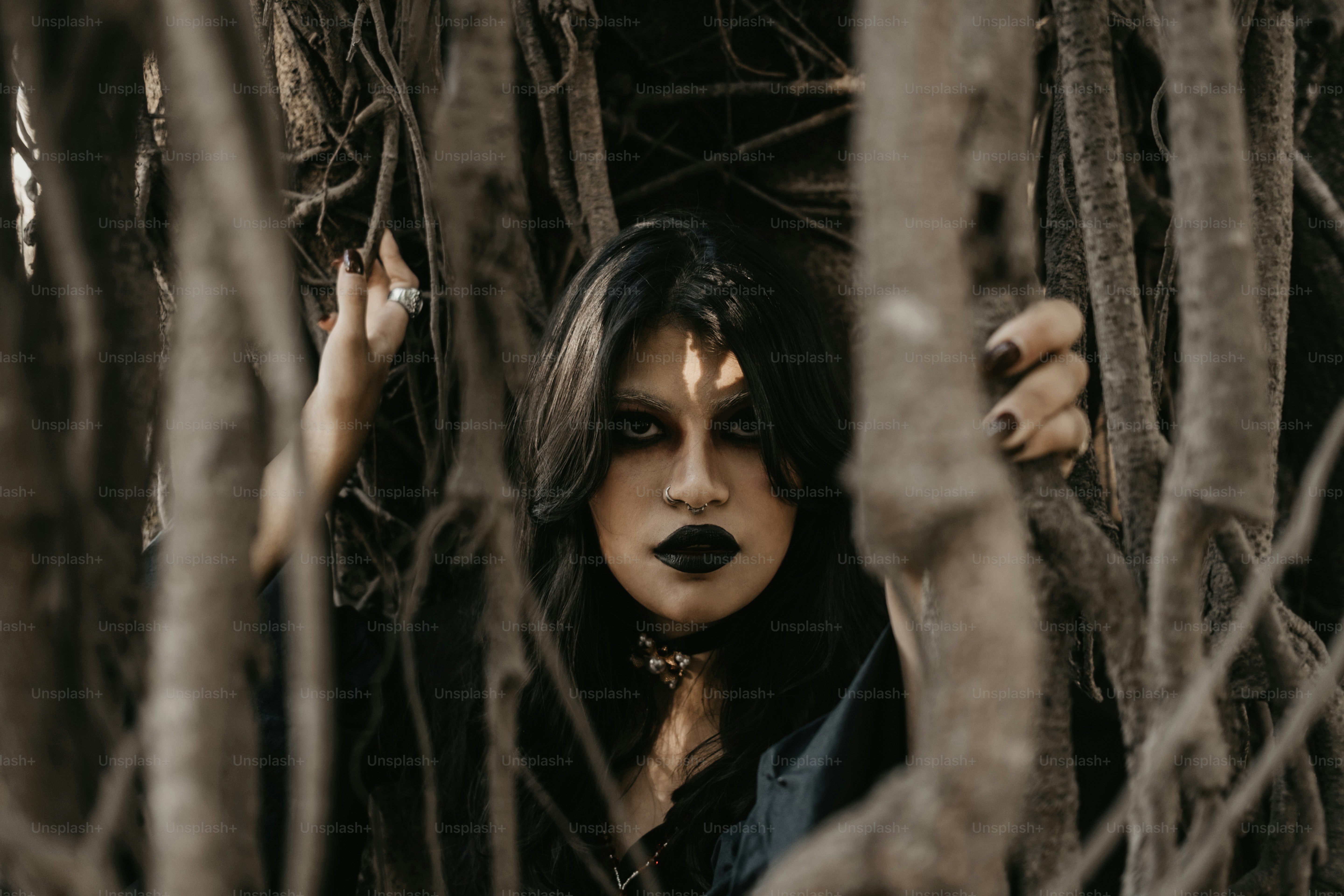 木々の間から暗いゴシック様式の女性が現れます。