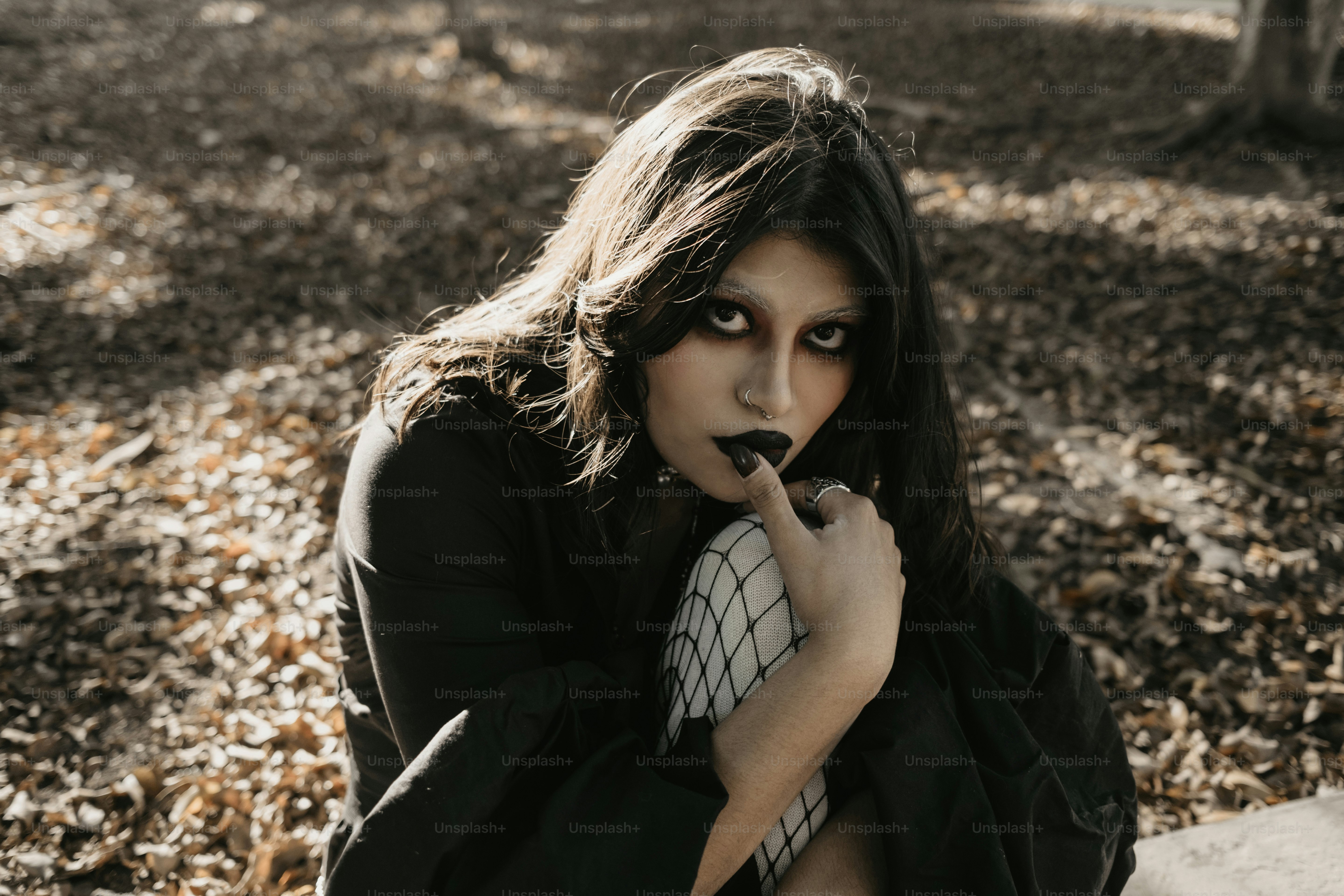A woman with dark makeup poses outside. photo – Fashion Image on Unsplash