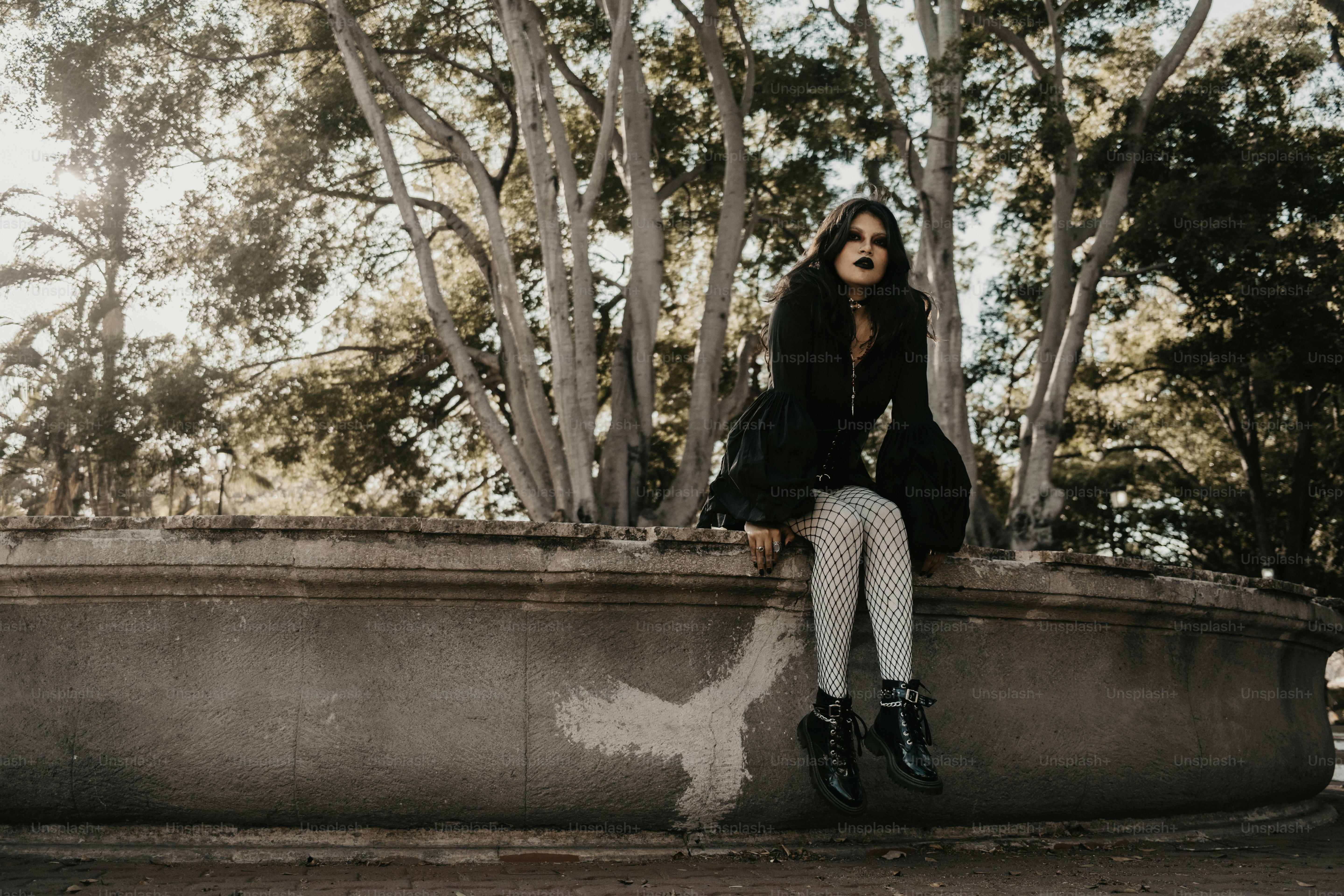 Uma mulher gótica senta-se em uma estrutura de pedra. foto – Imagem sobre  Moda na Unsplash, image size:3000x2000