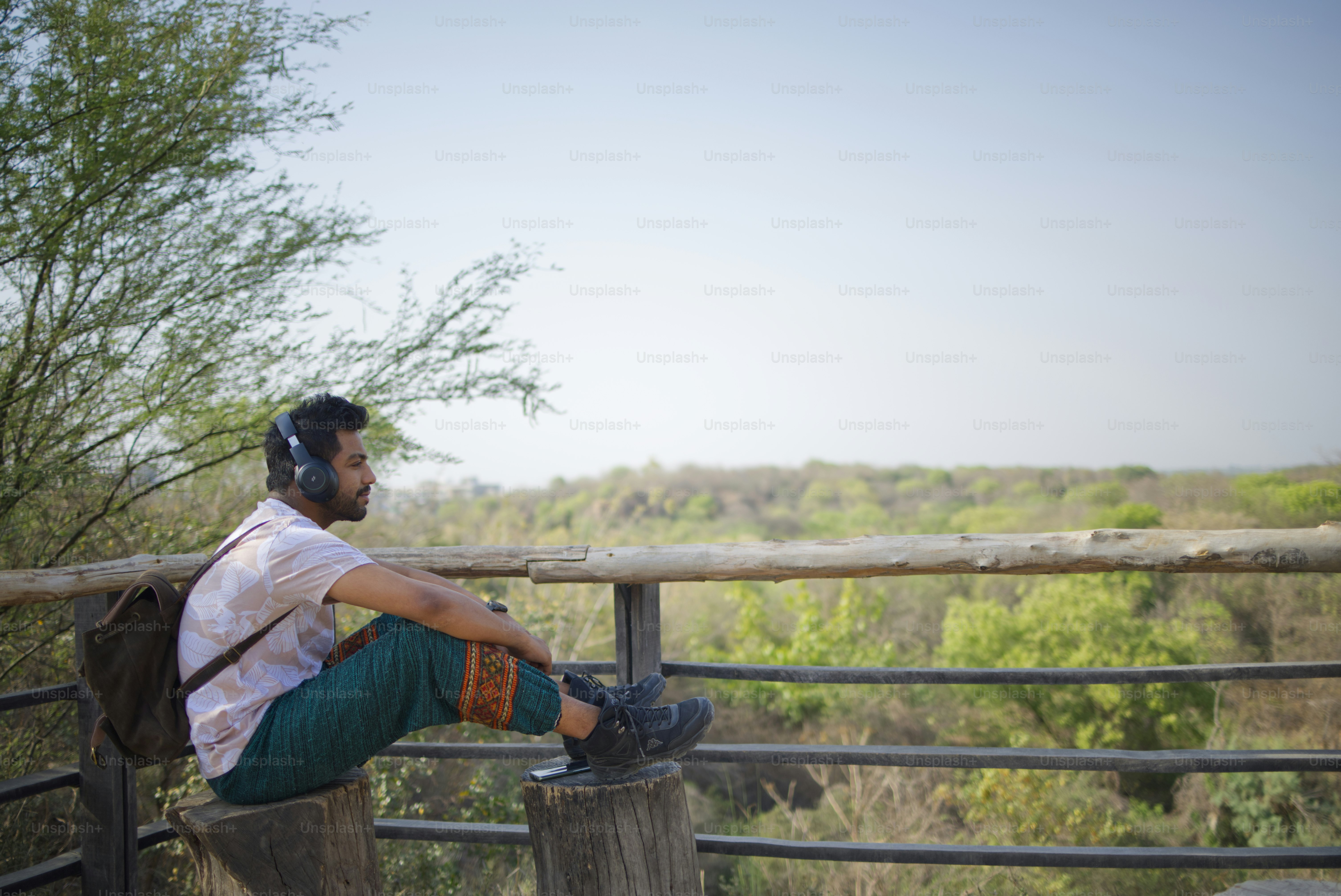Man enjoys view with headphones in nature.