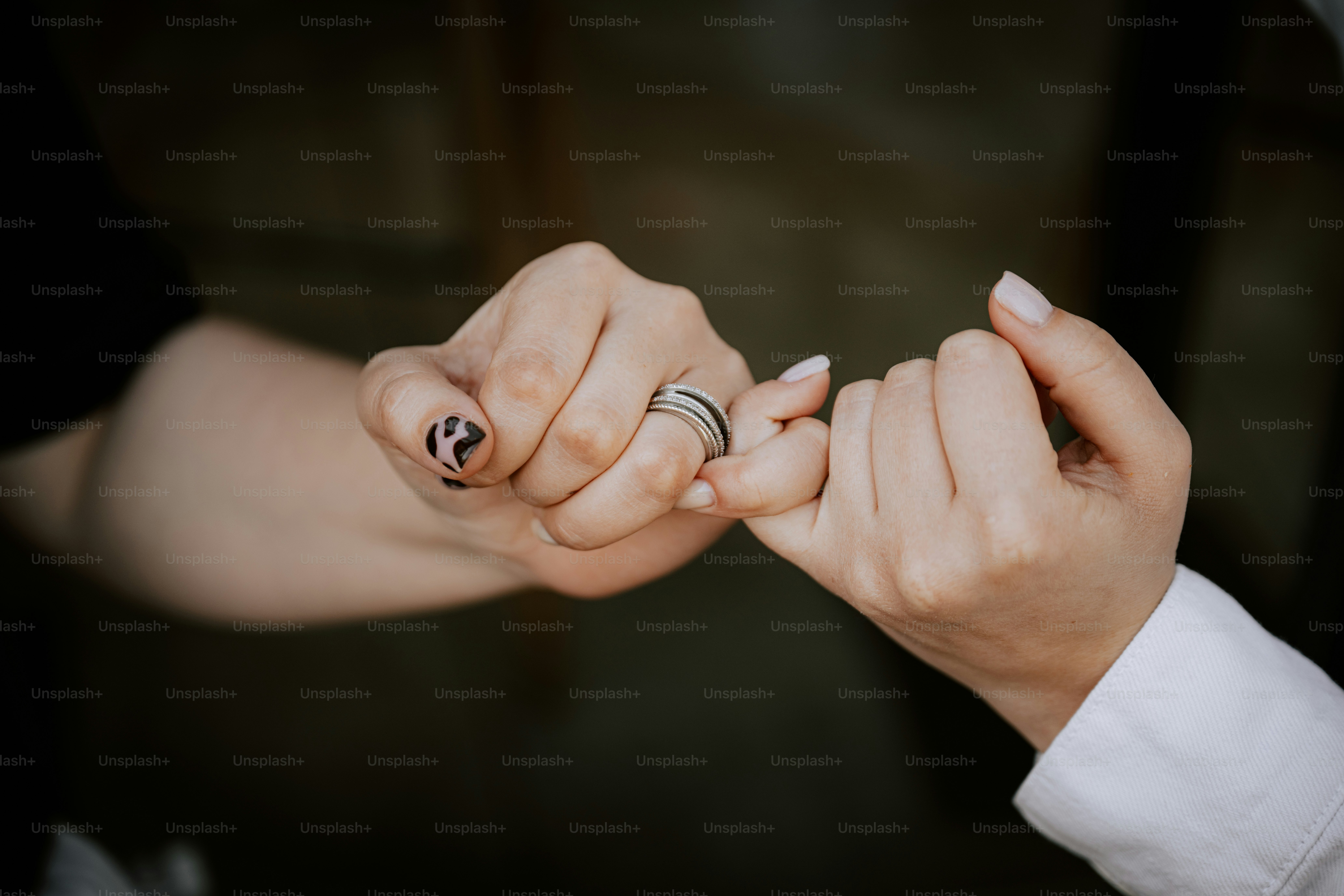 Two people pinky promise to each other.