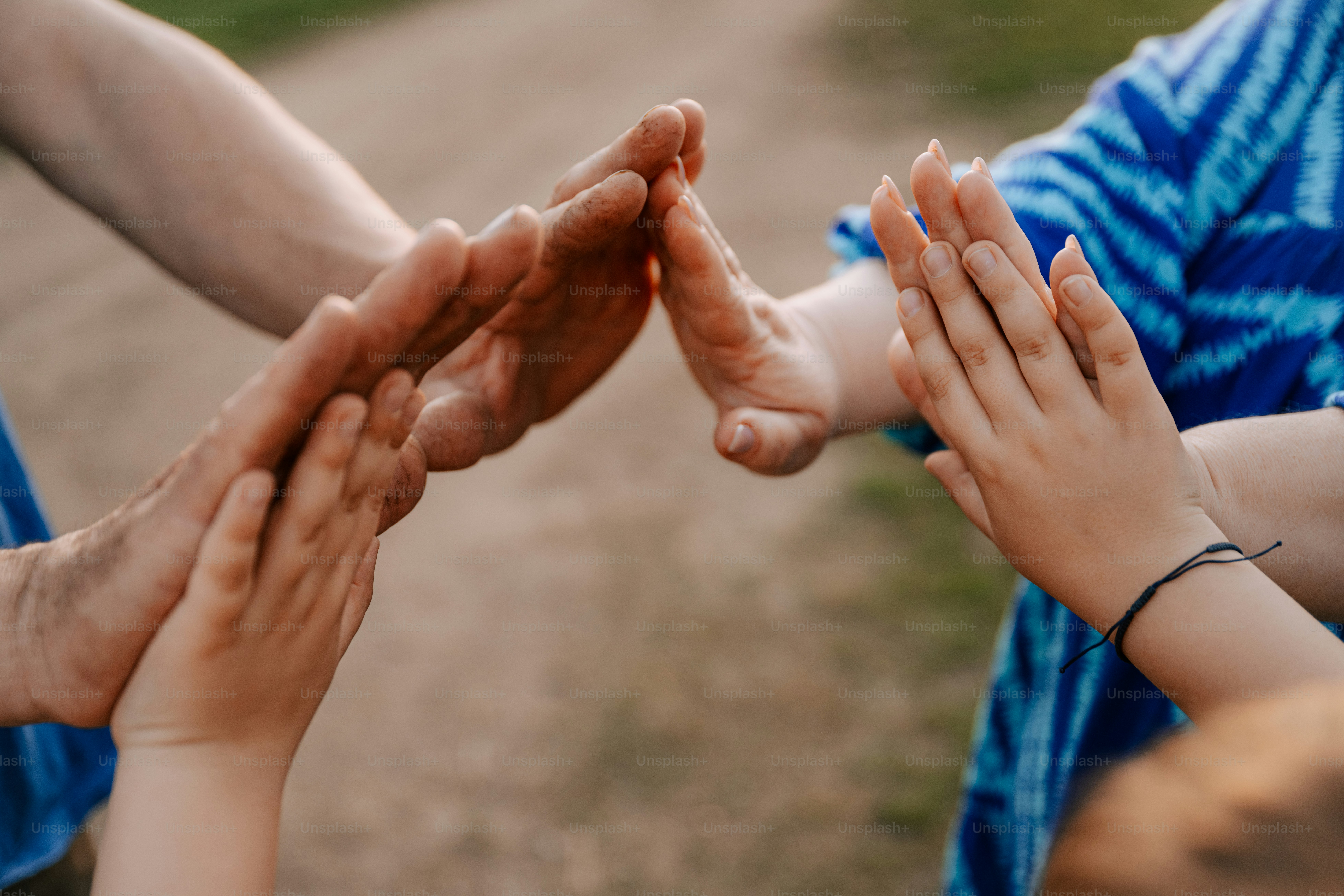 People are touching hands in a sign of connection.