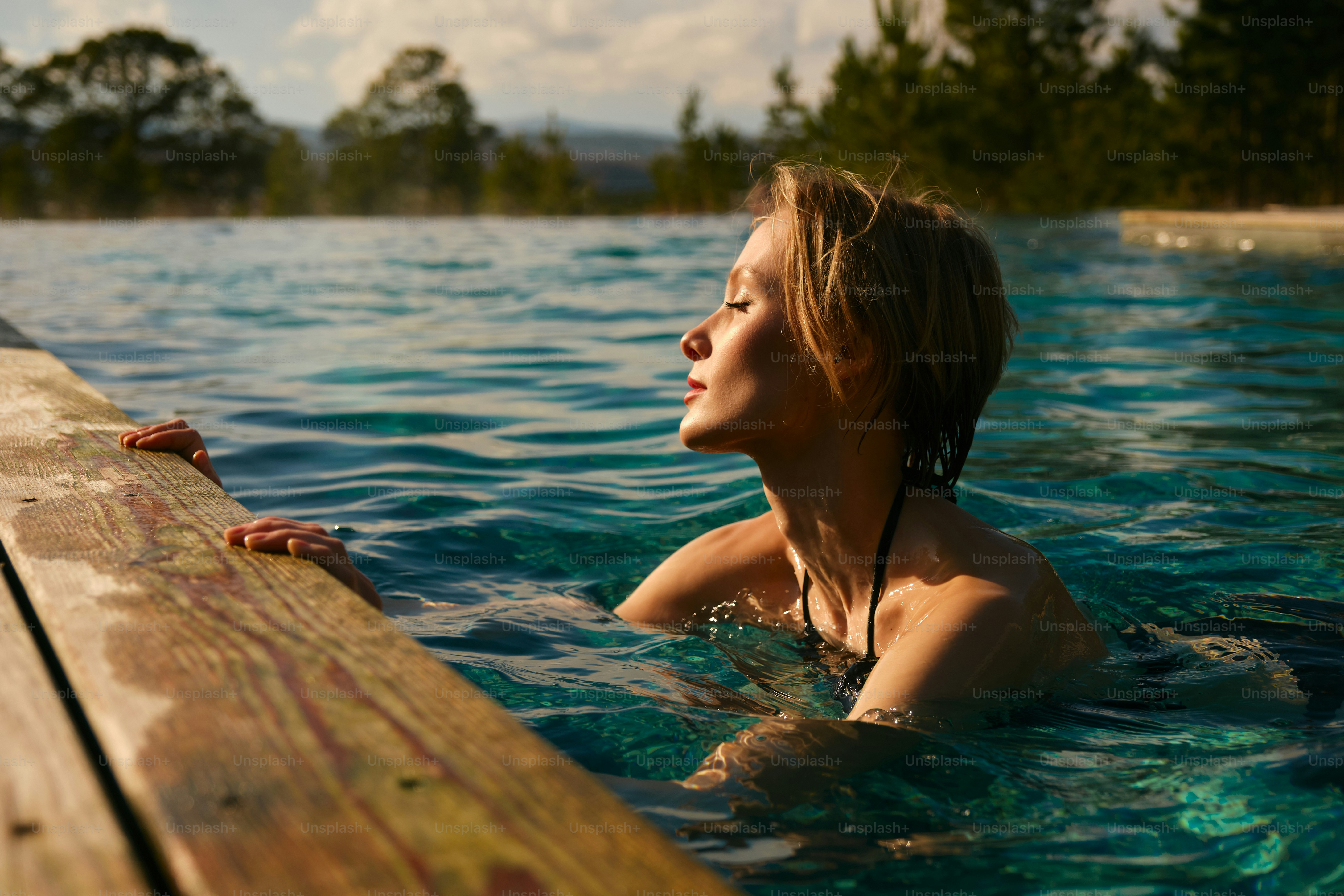 Woman relaxes in a pool with her eyes closed.