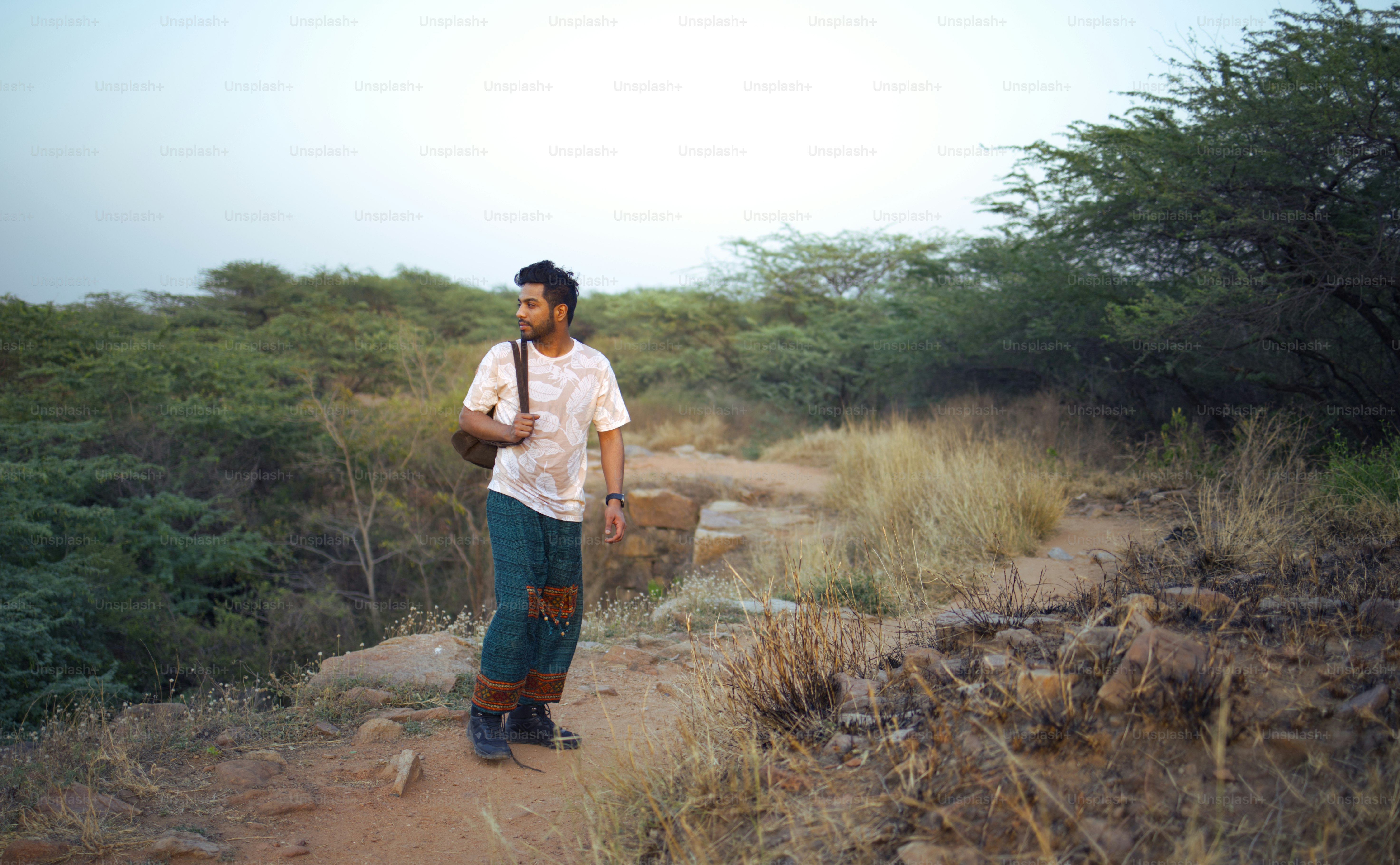 A man is walking outdoors on a path.