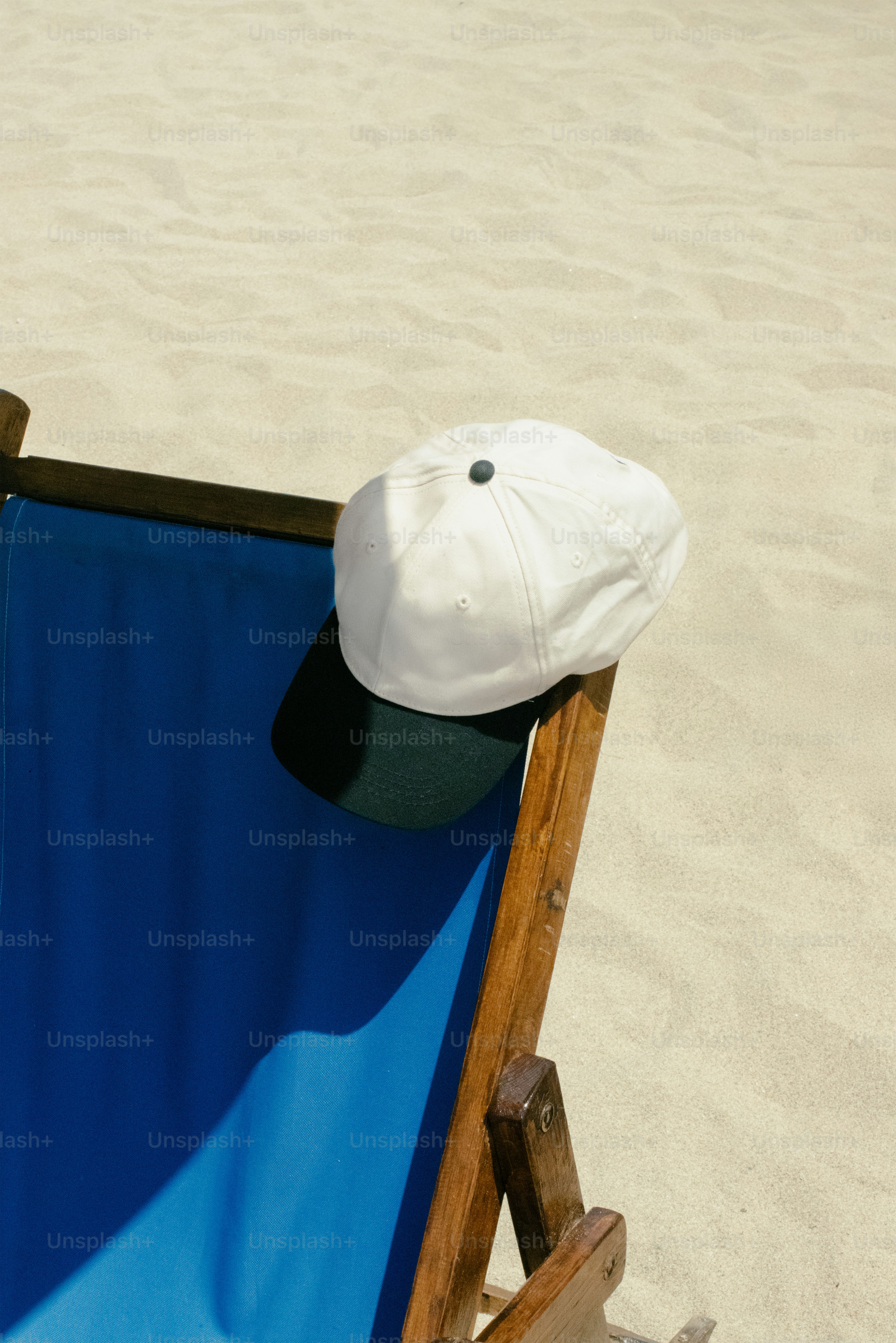 A white hat rests on a beach chair.