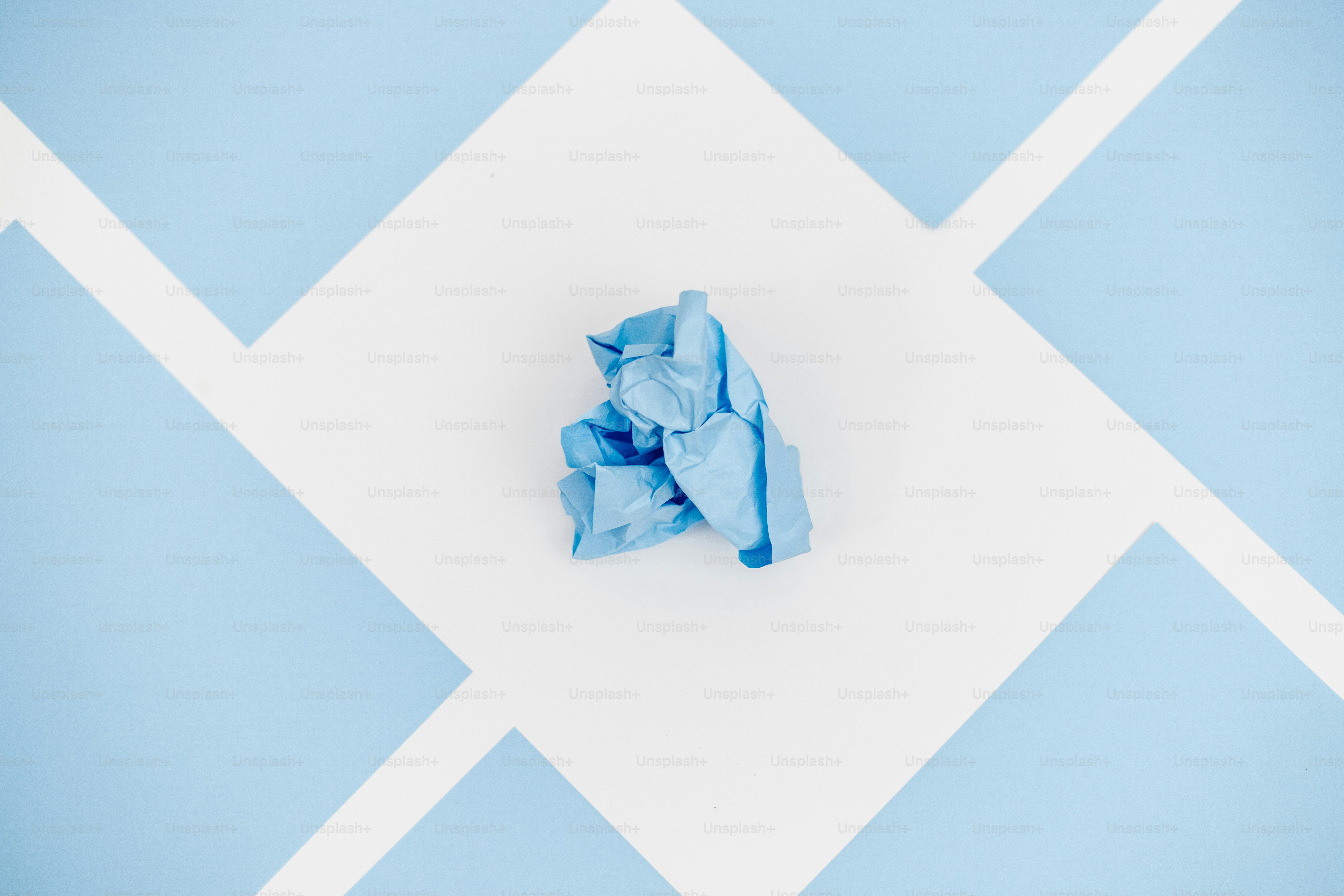 Uma luva azul amassada está em um desenho geométrico.