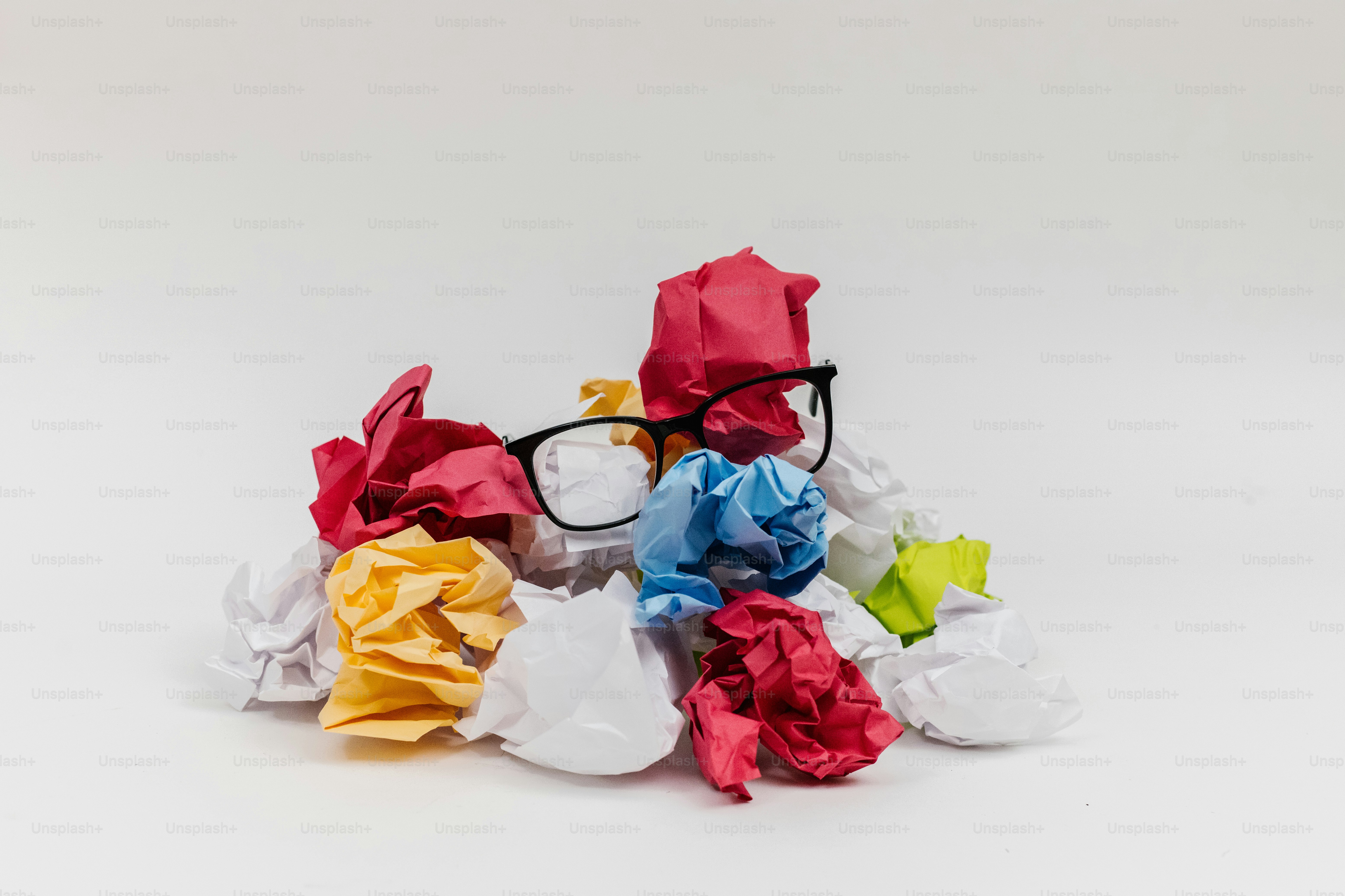 Os copos repousam sobre uma pilha colorida de papel amassado.