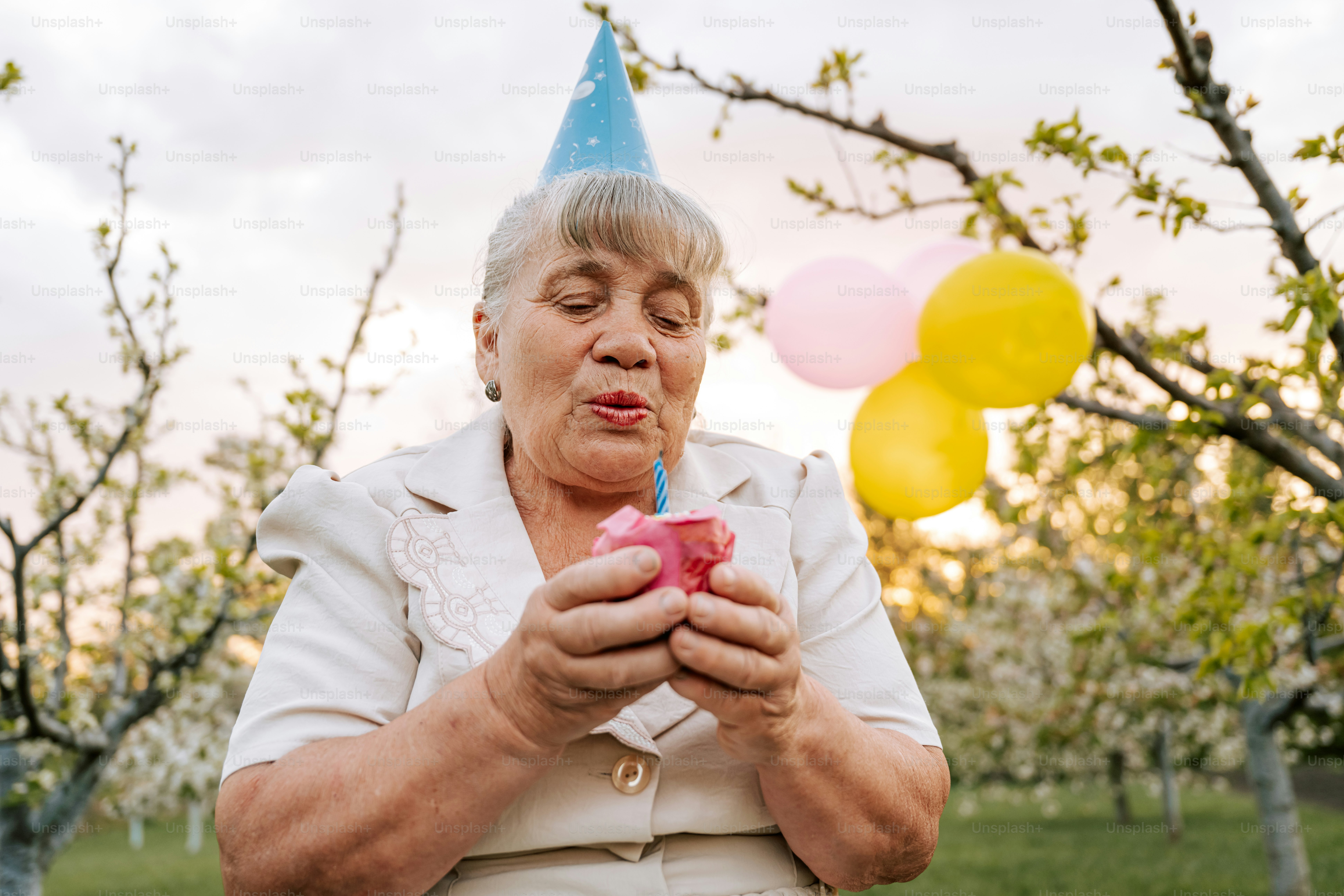 Woman blows out a birthday candle.