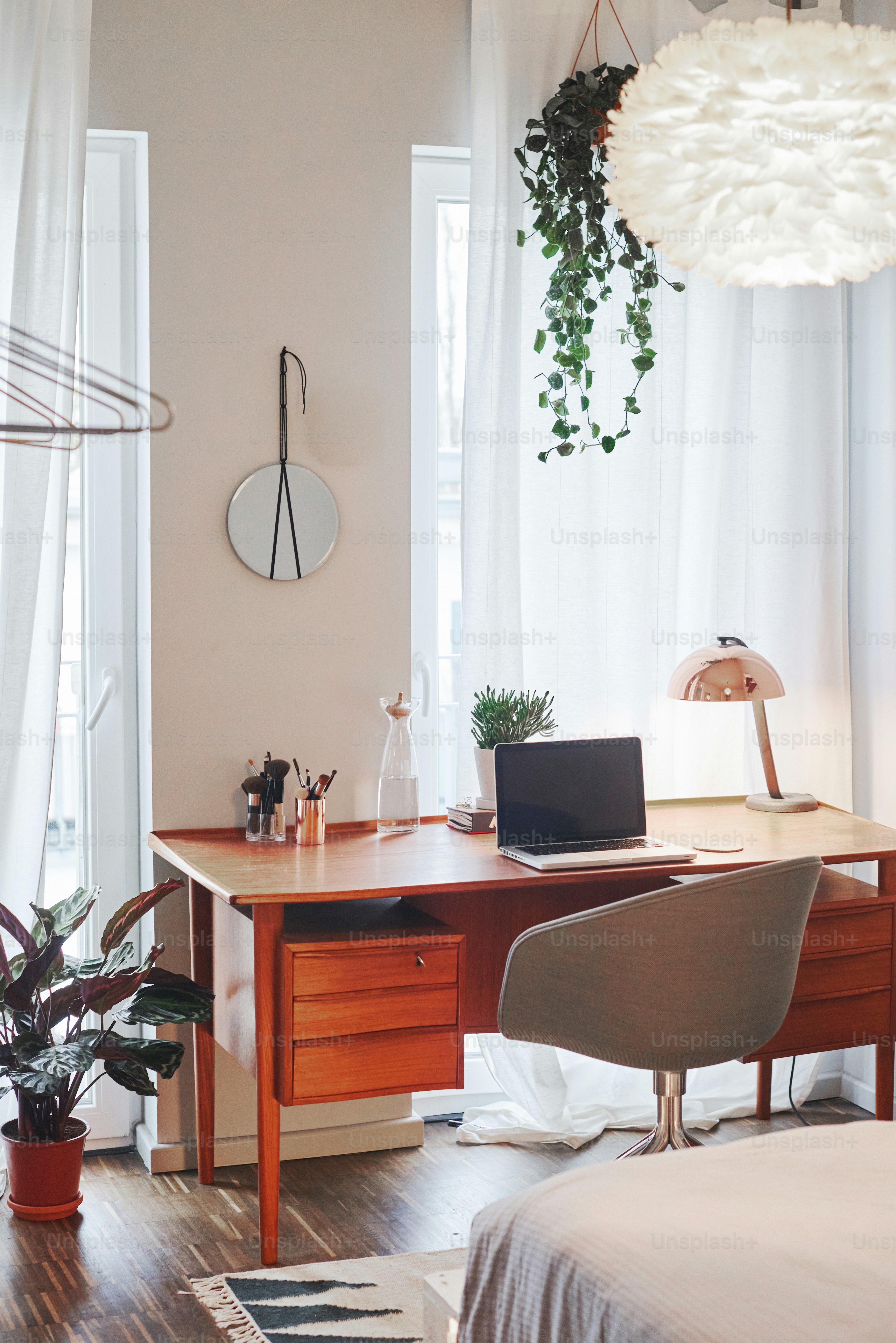 Cozy home office with desk, laptop, and plants.