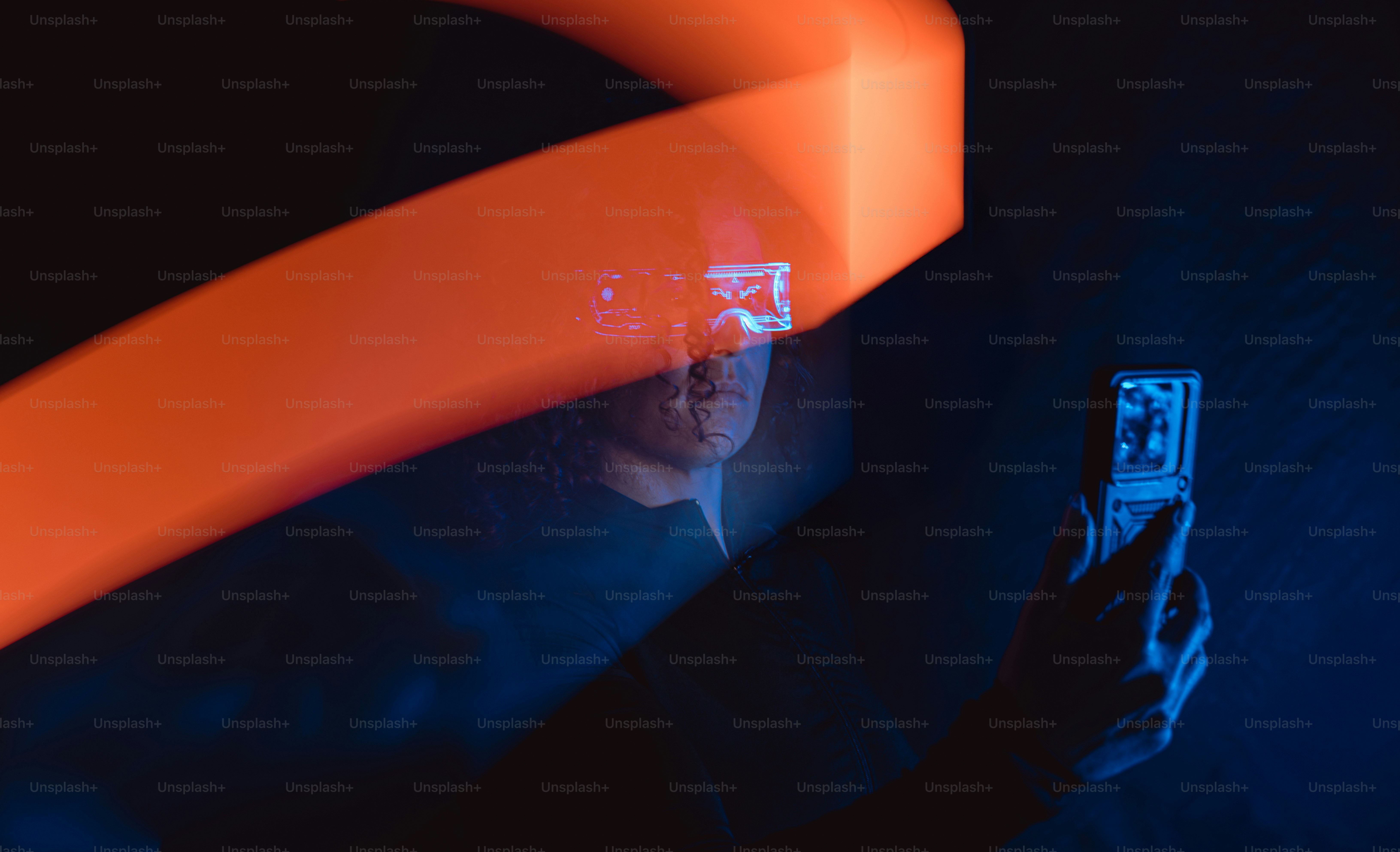 Une personne regarde un téléphone avec une lumière orange.