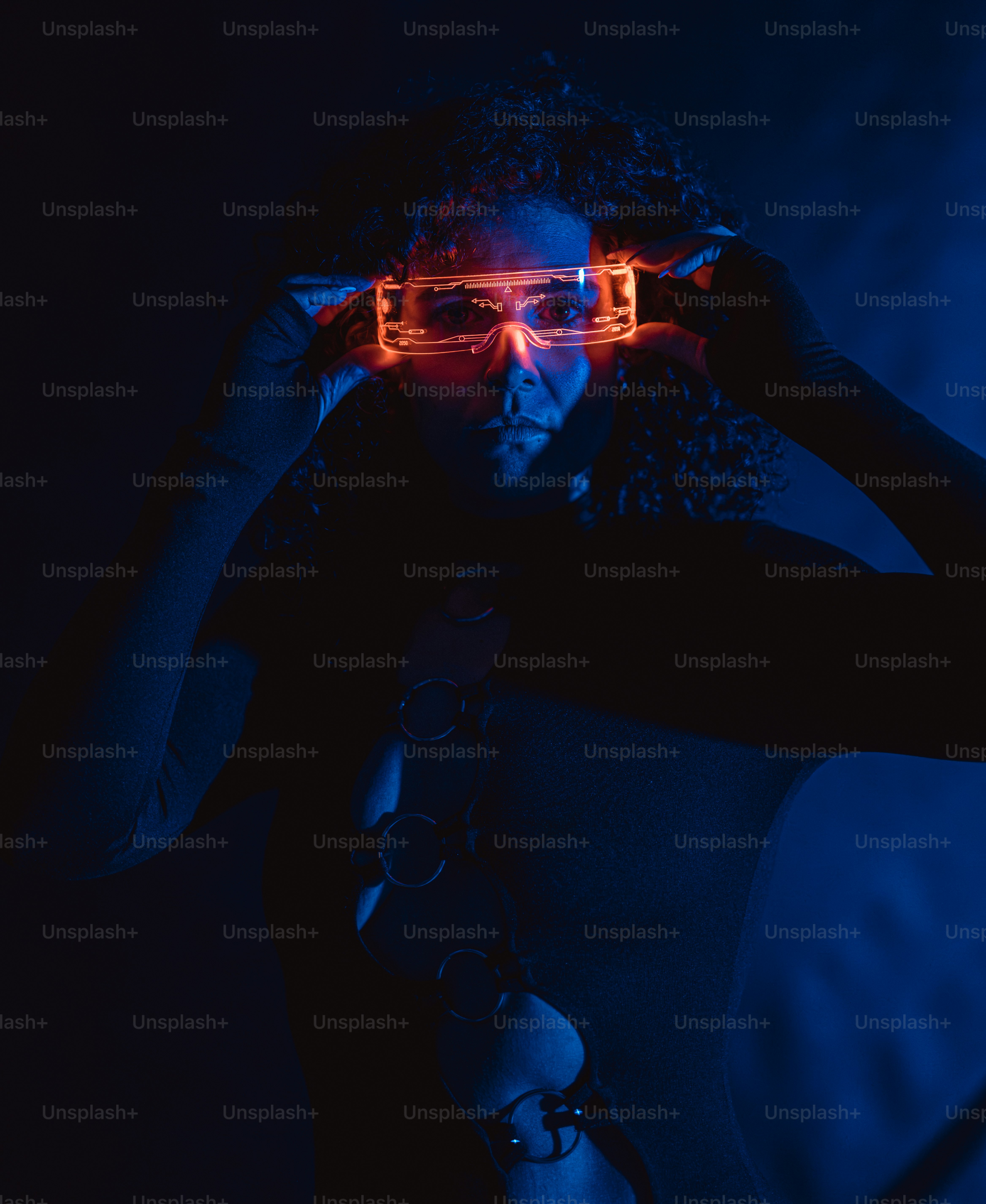 Woman wearing illuminated futuristic glasses in a dark room.