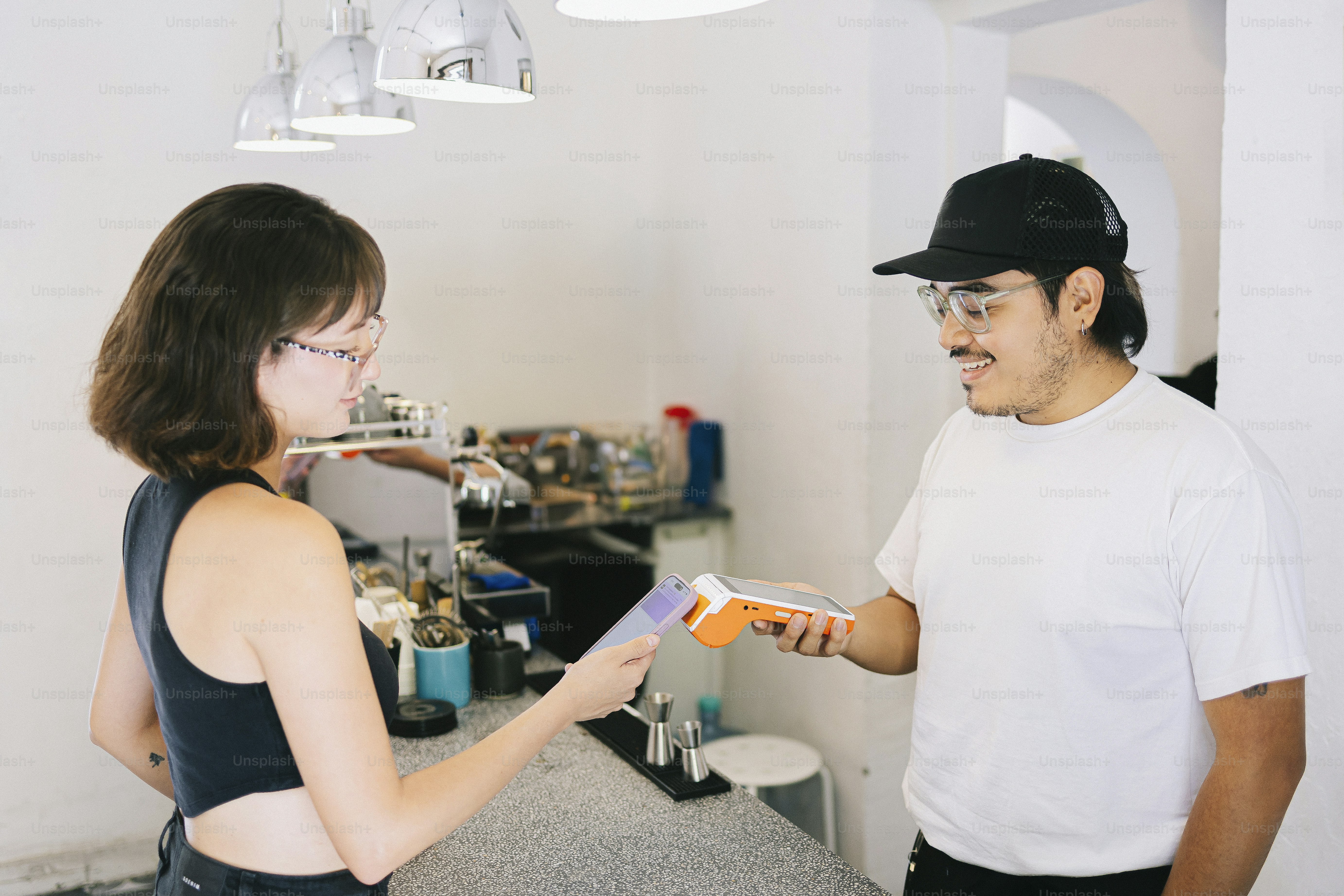 Ein Barista erhält die Zahlung von einem Kunden.