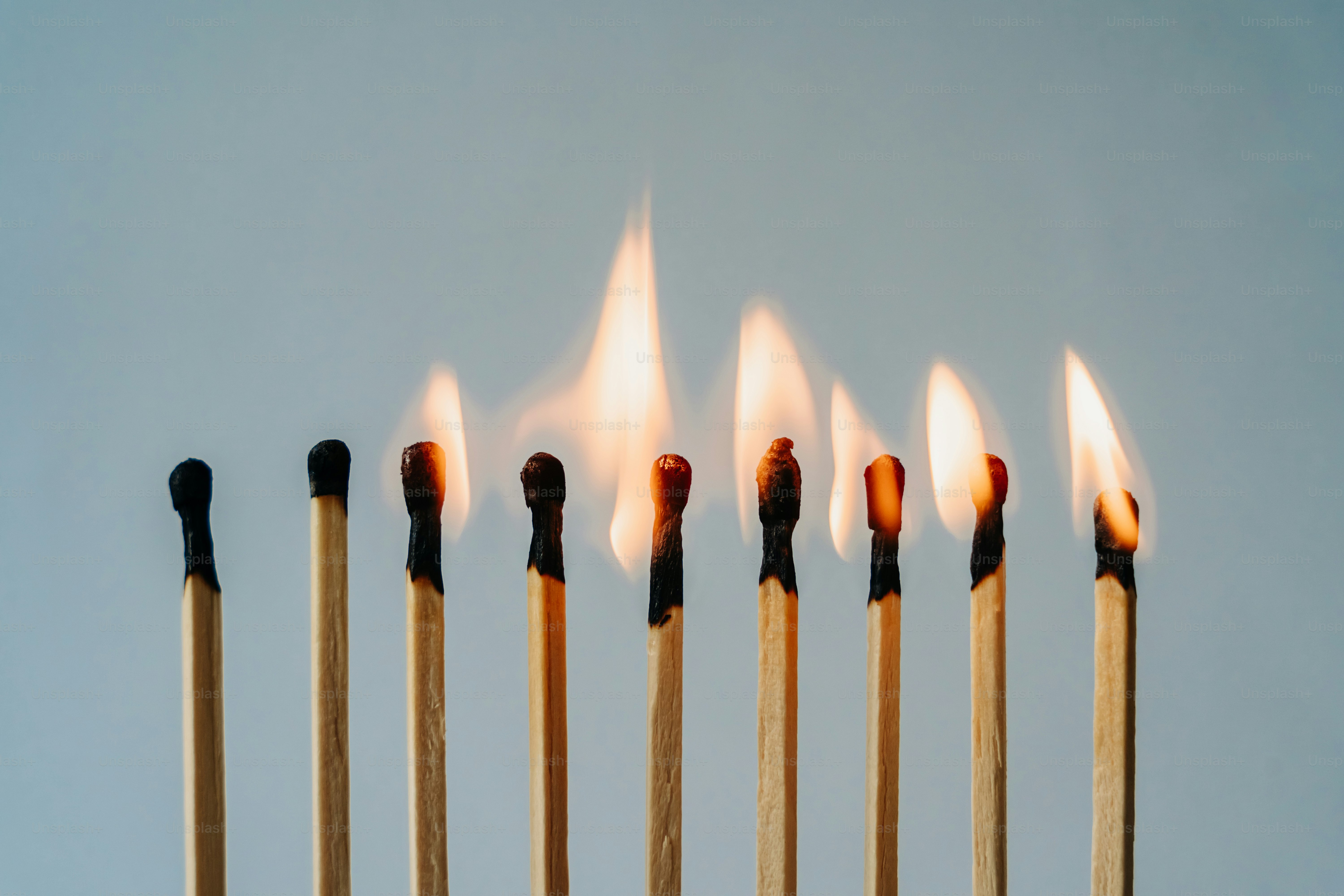 Burning matches illuminate in a row.