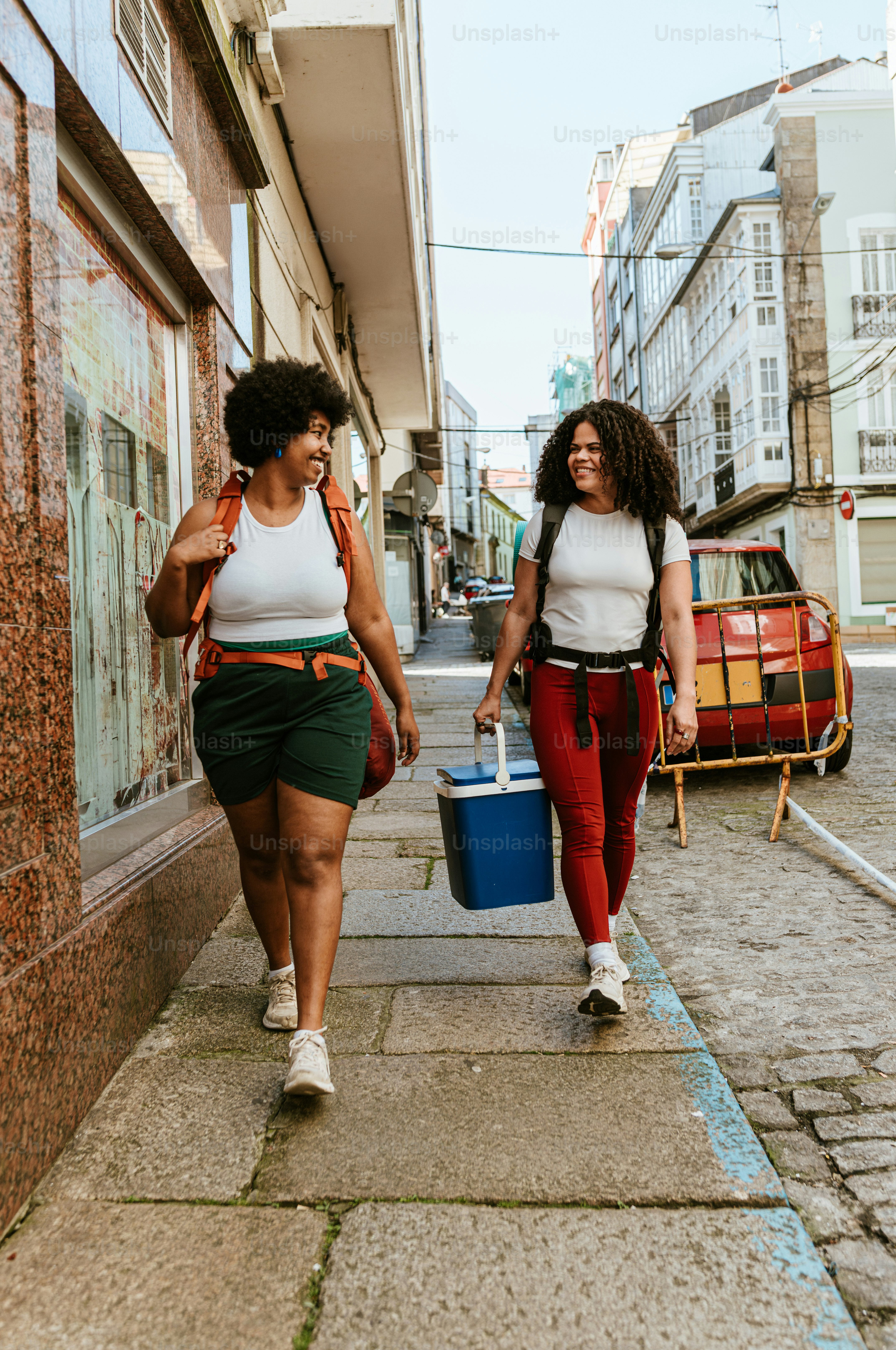 Two women walk down a city street.