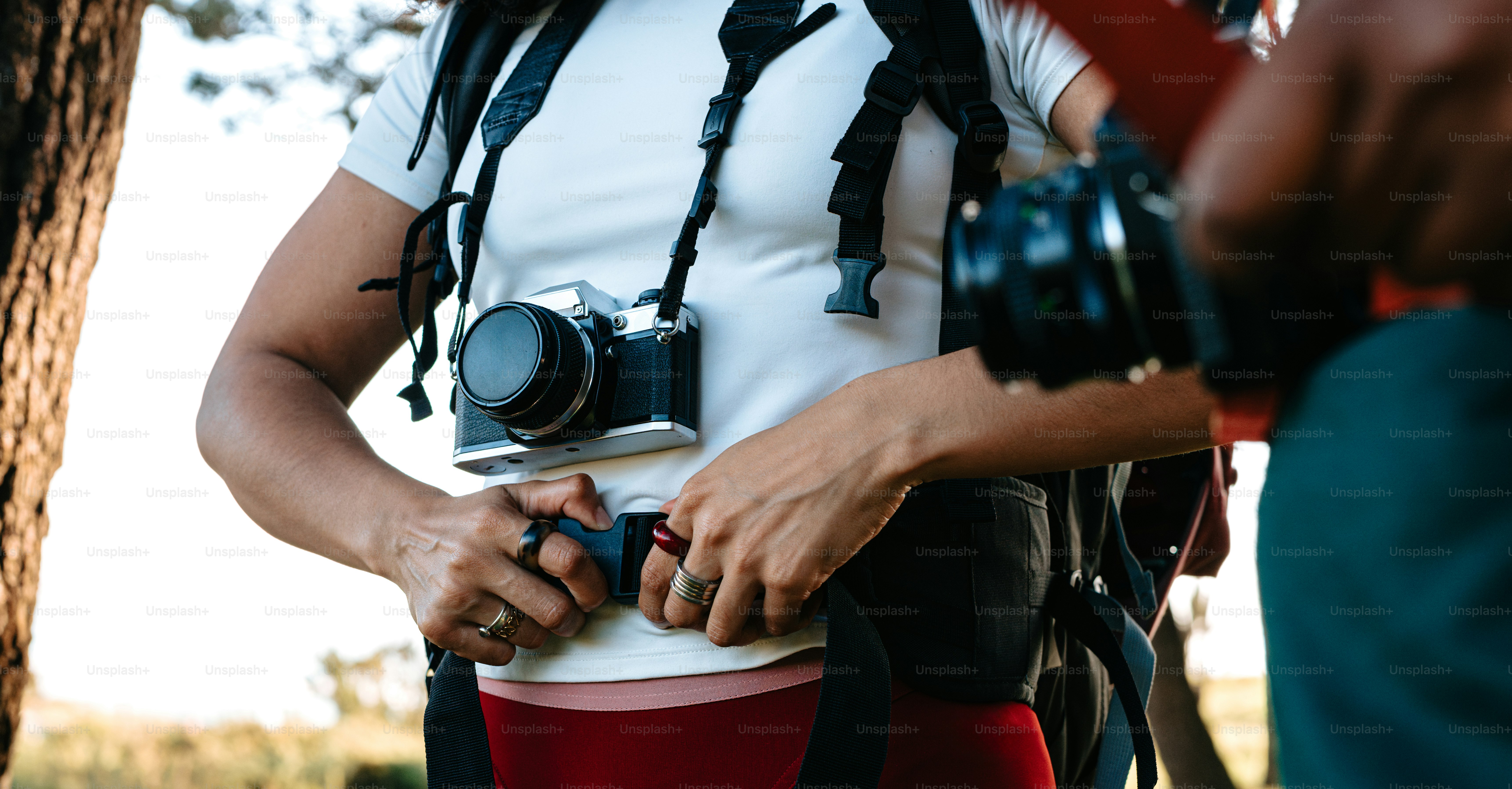 A person adjusts their backpack strap.