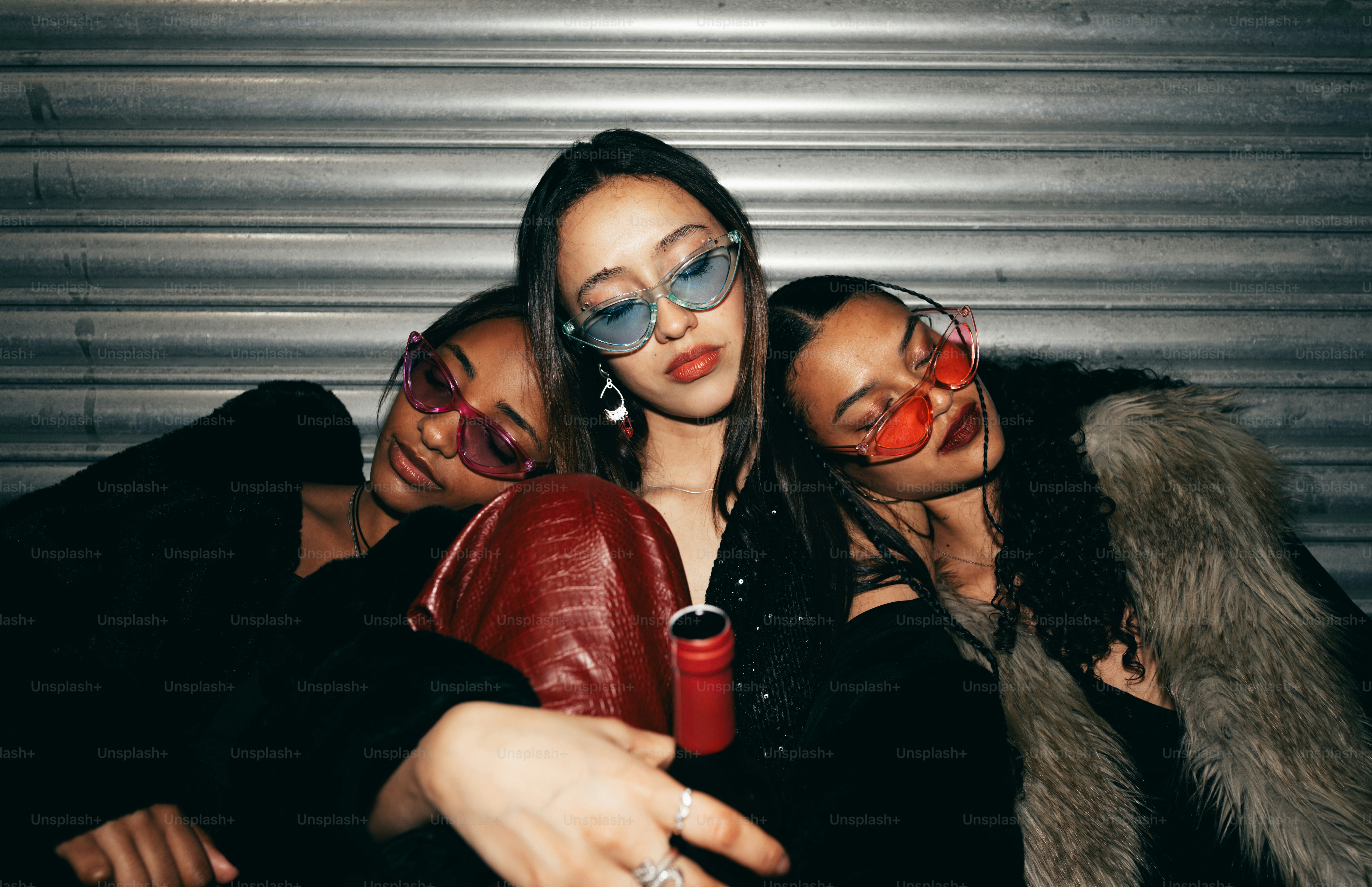 Tres mujeres elegantes con gafas de sol de colores posan