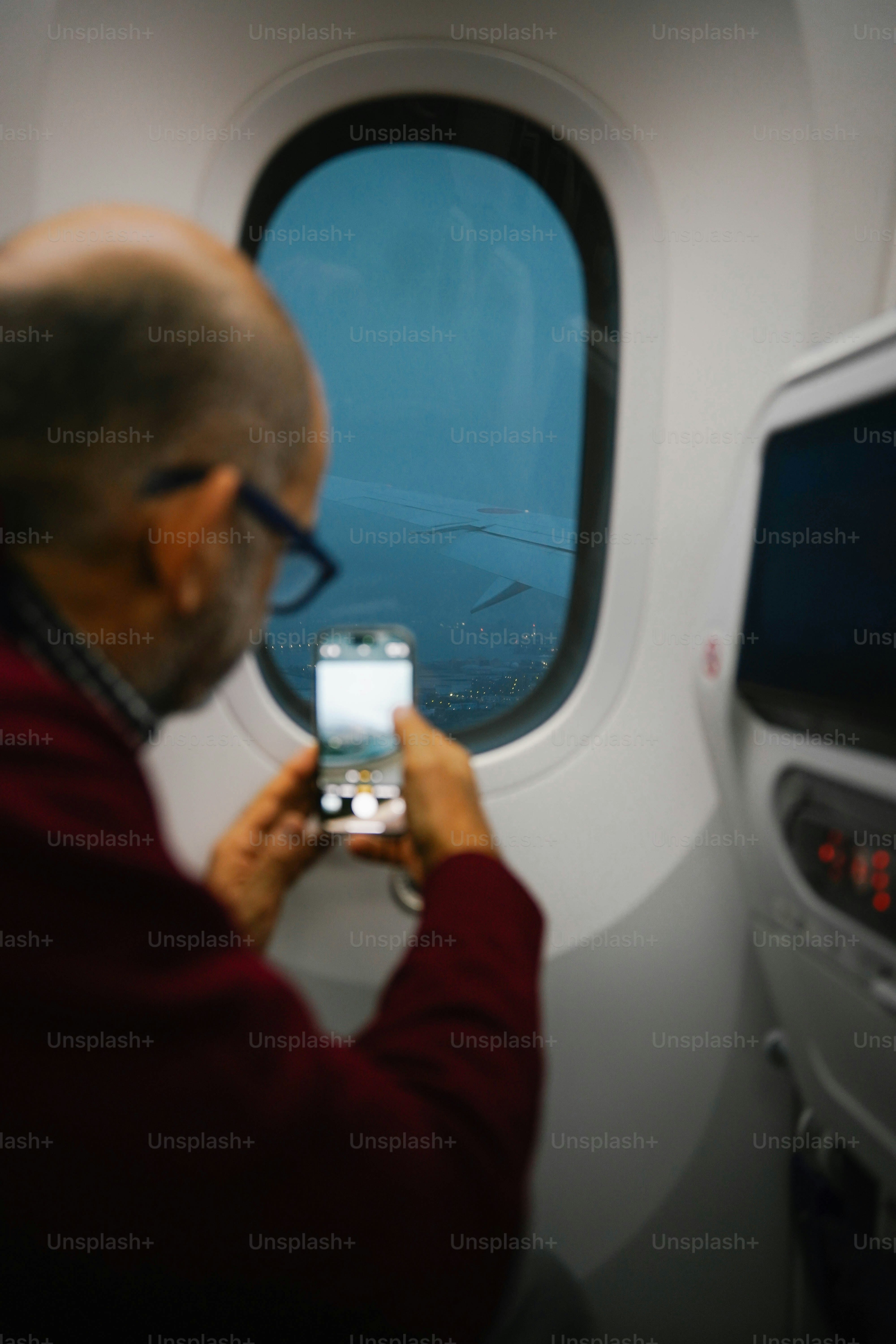 A man takes a photo out of airplane window.