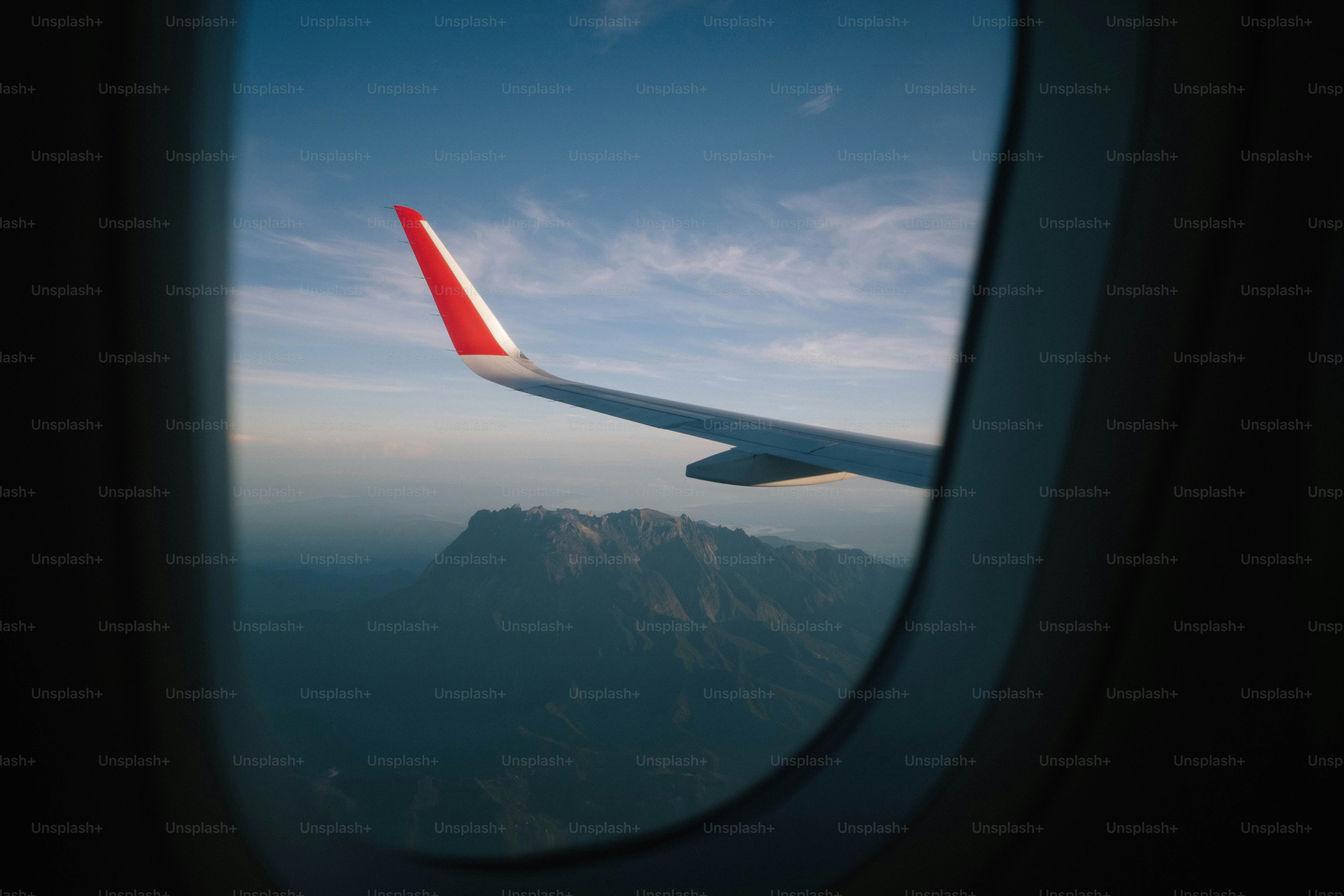 An airplane wing views mountainous landscapes