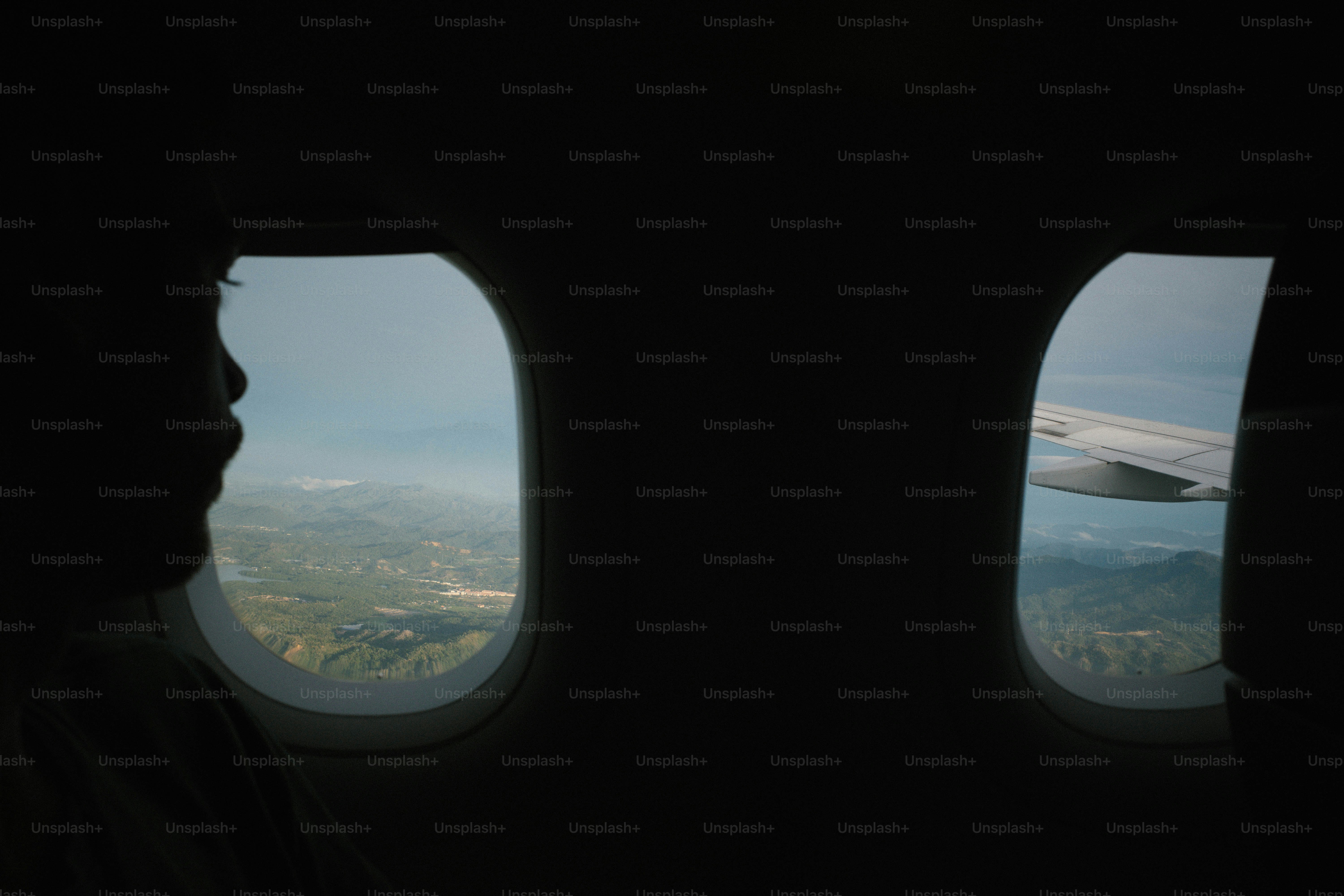 A person looks out the airplane window.