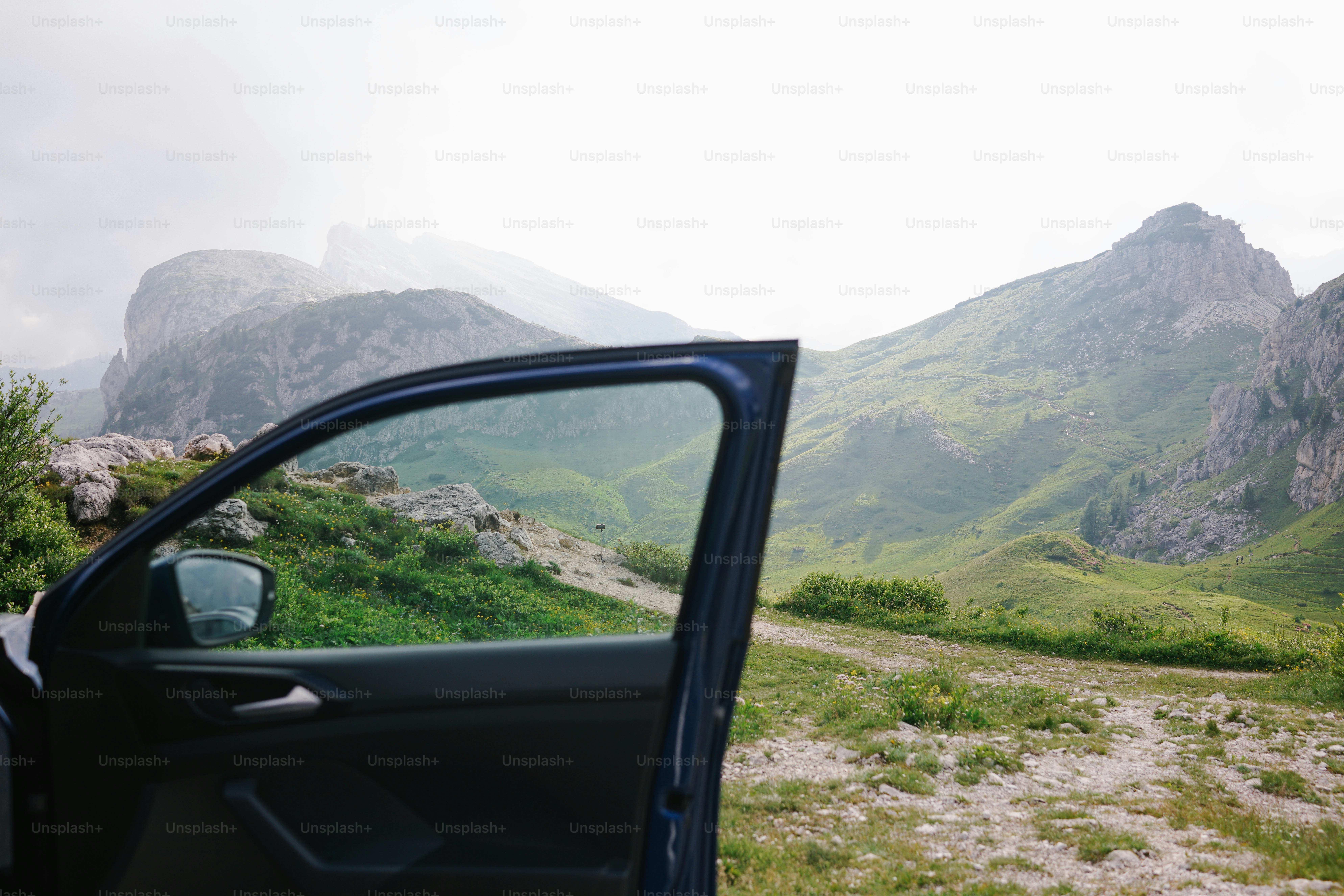 Open car door reveals stunning mountain view.
