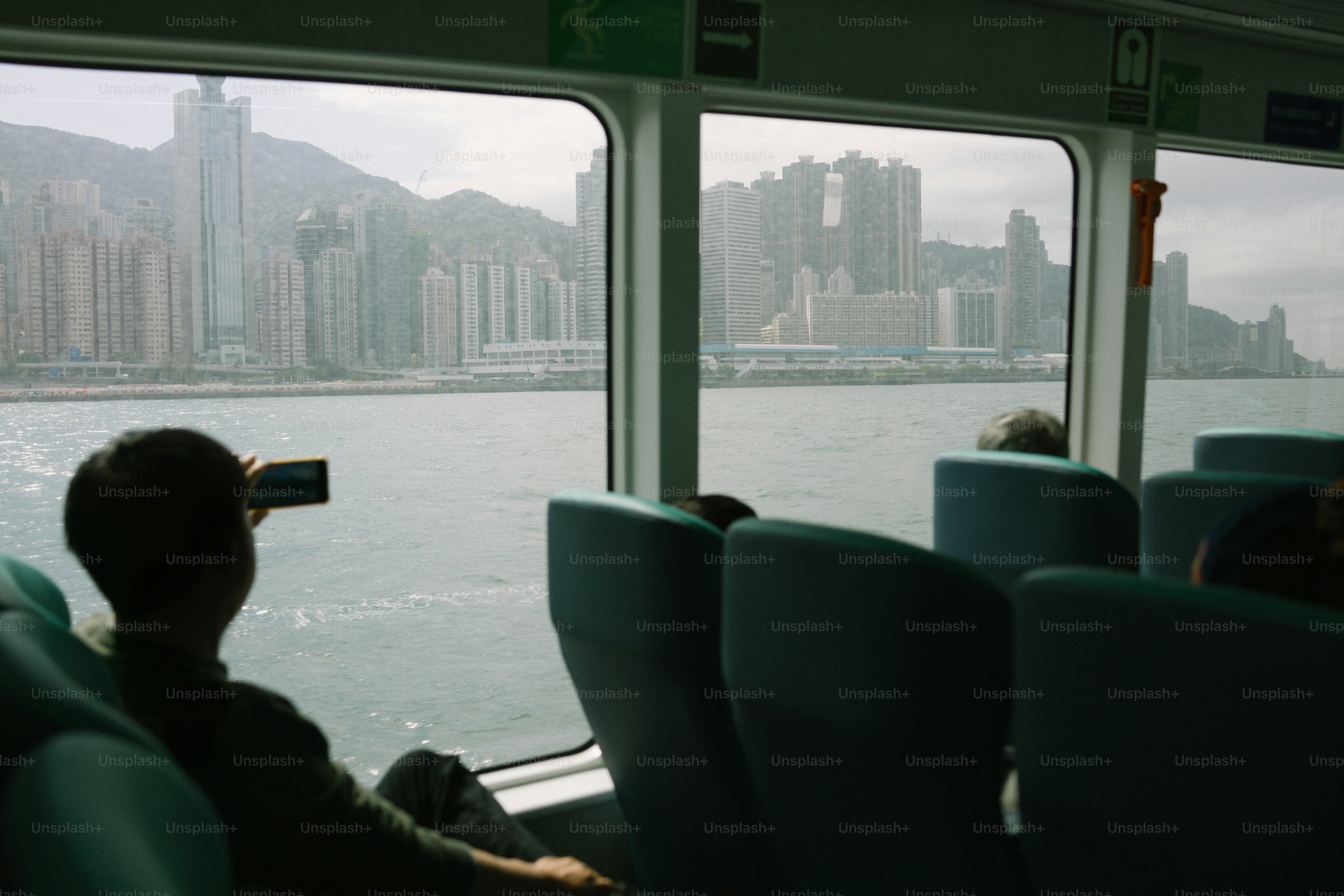 페리 승객이 도시의 사진을 찍고 있습니다.