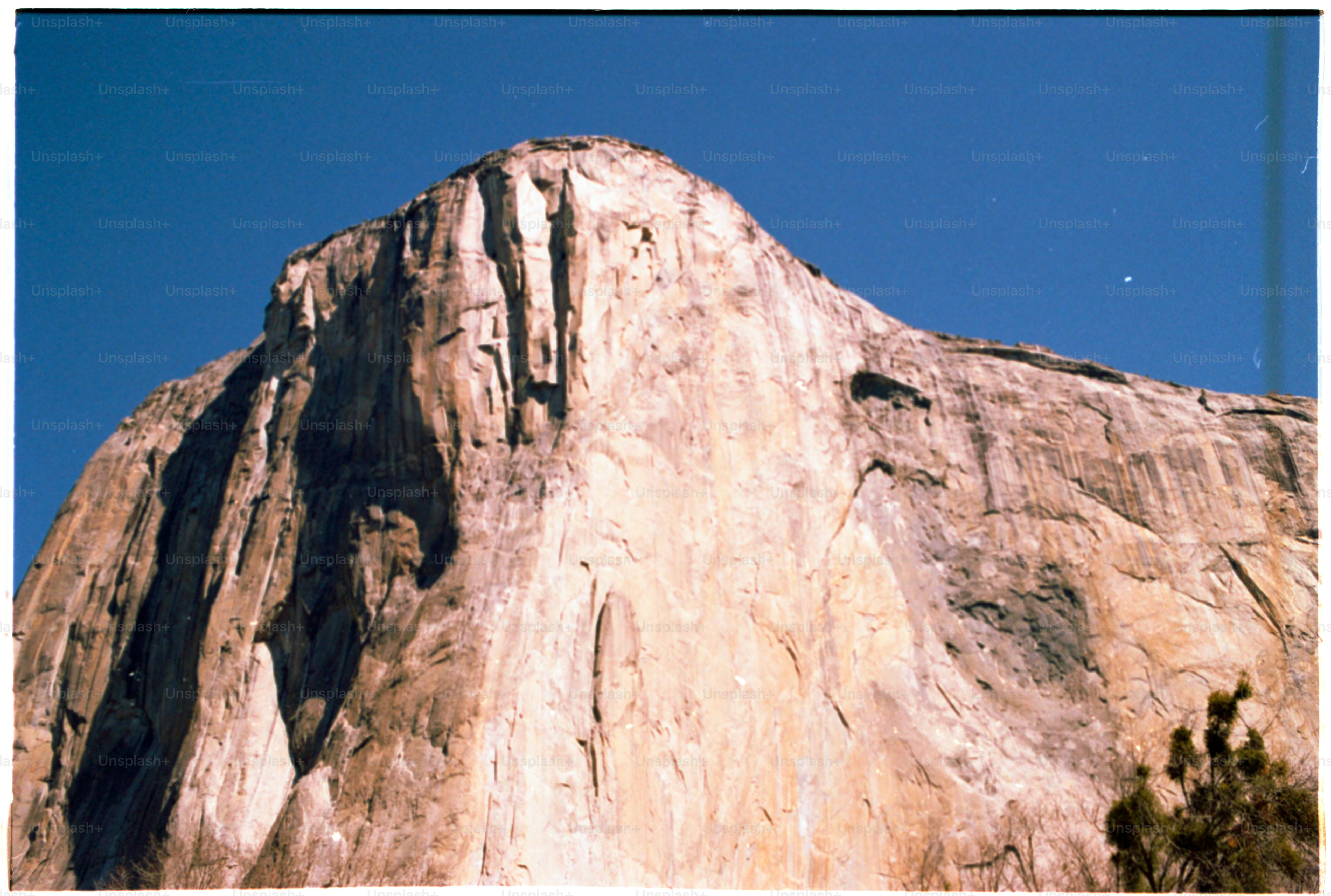 A majestic mountain soars against a blue sky.
