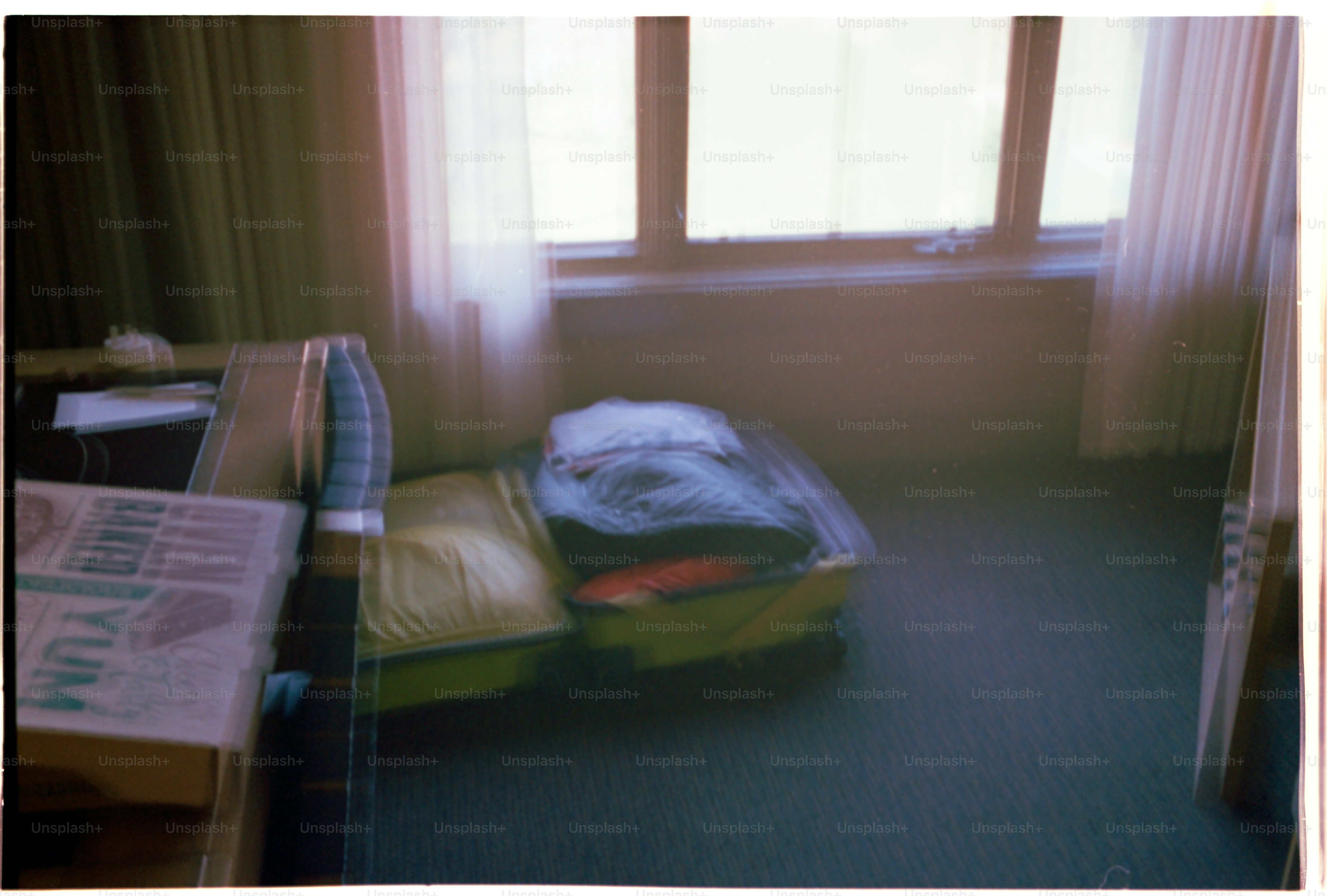 A suitcase sits in a blurry hotel room.