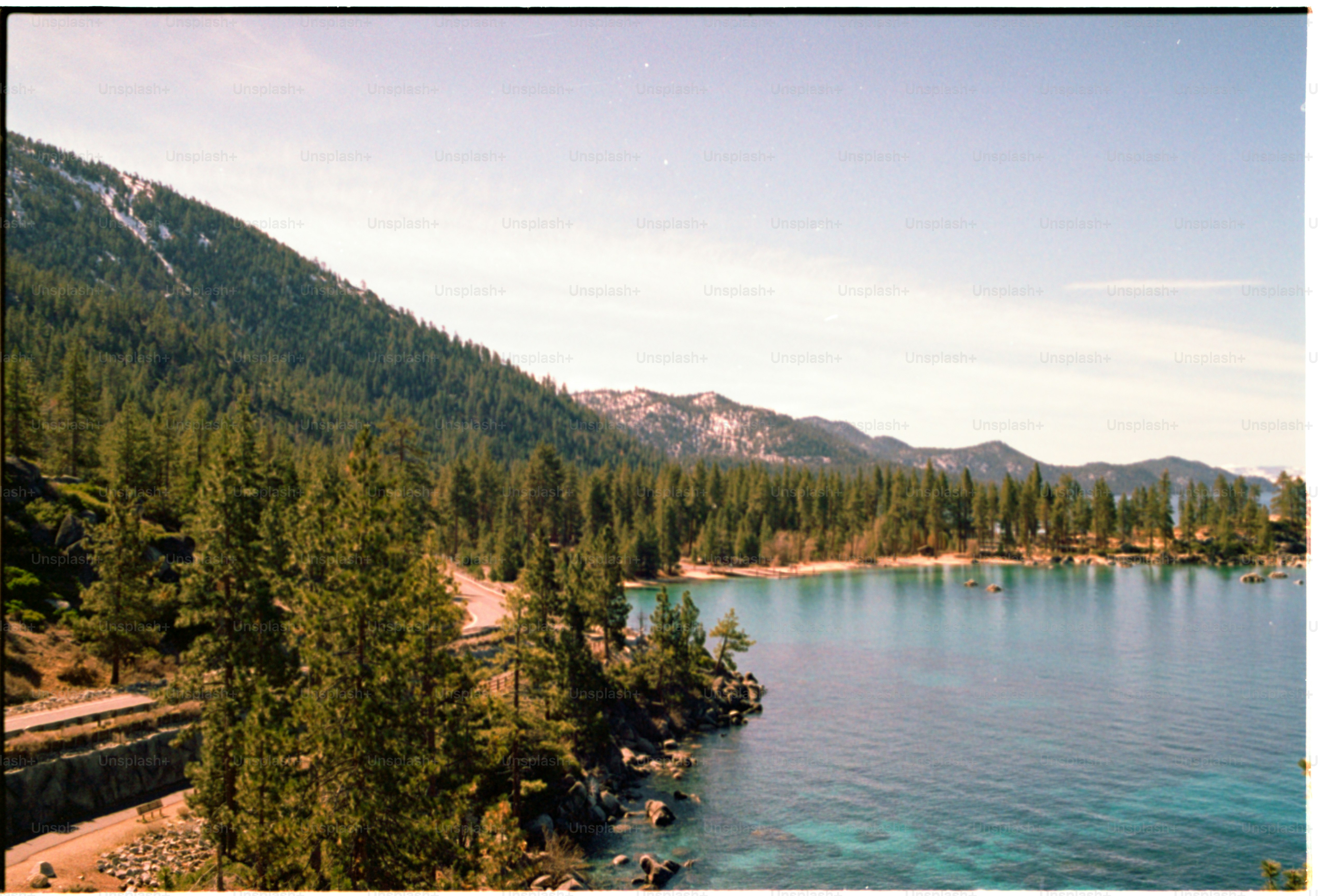 Vue panoramique sur le lac avec des montagnes et des arbres.