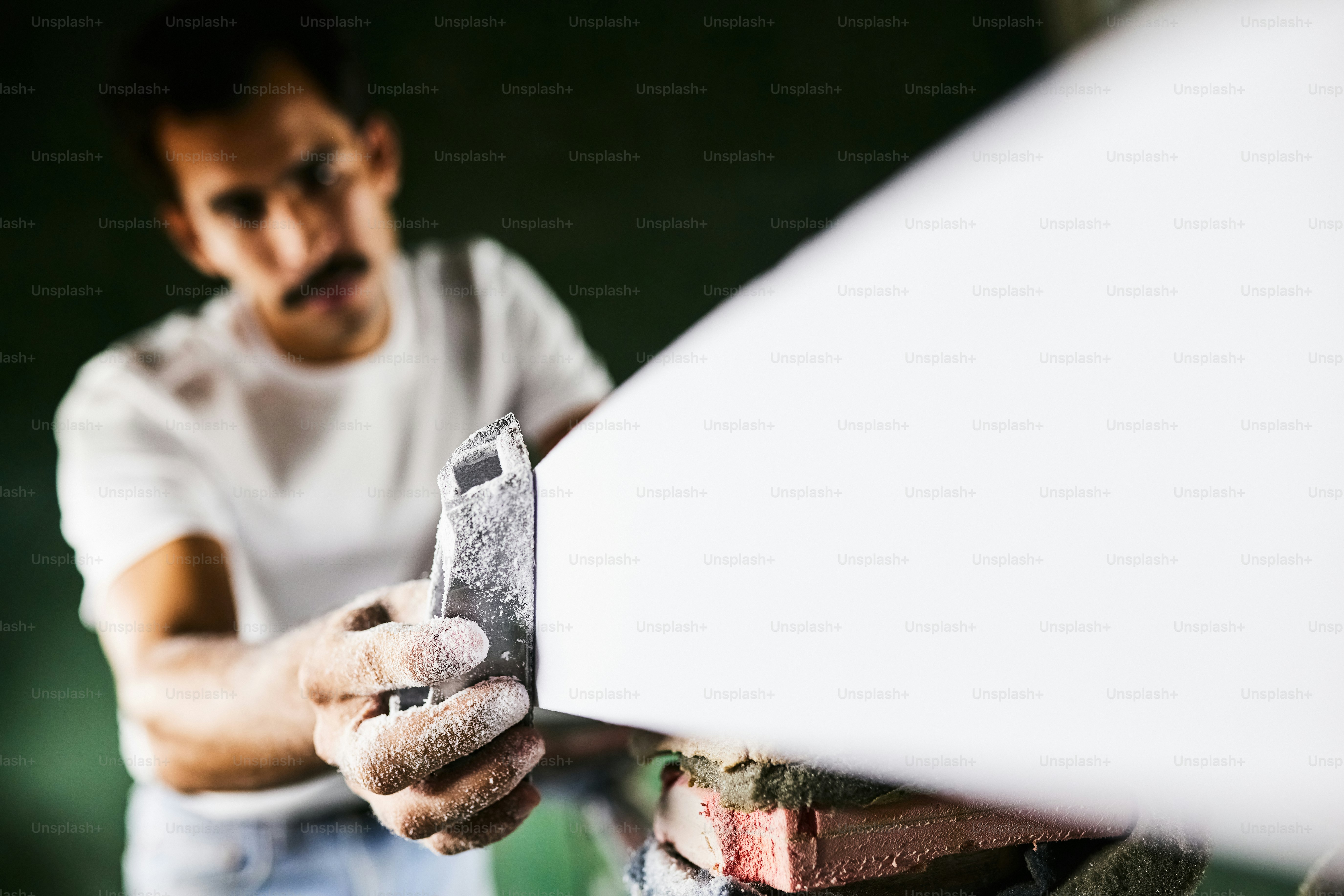 한 남자가 서핑 보드를 만들고 있습니다.