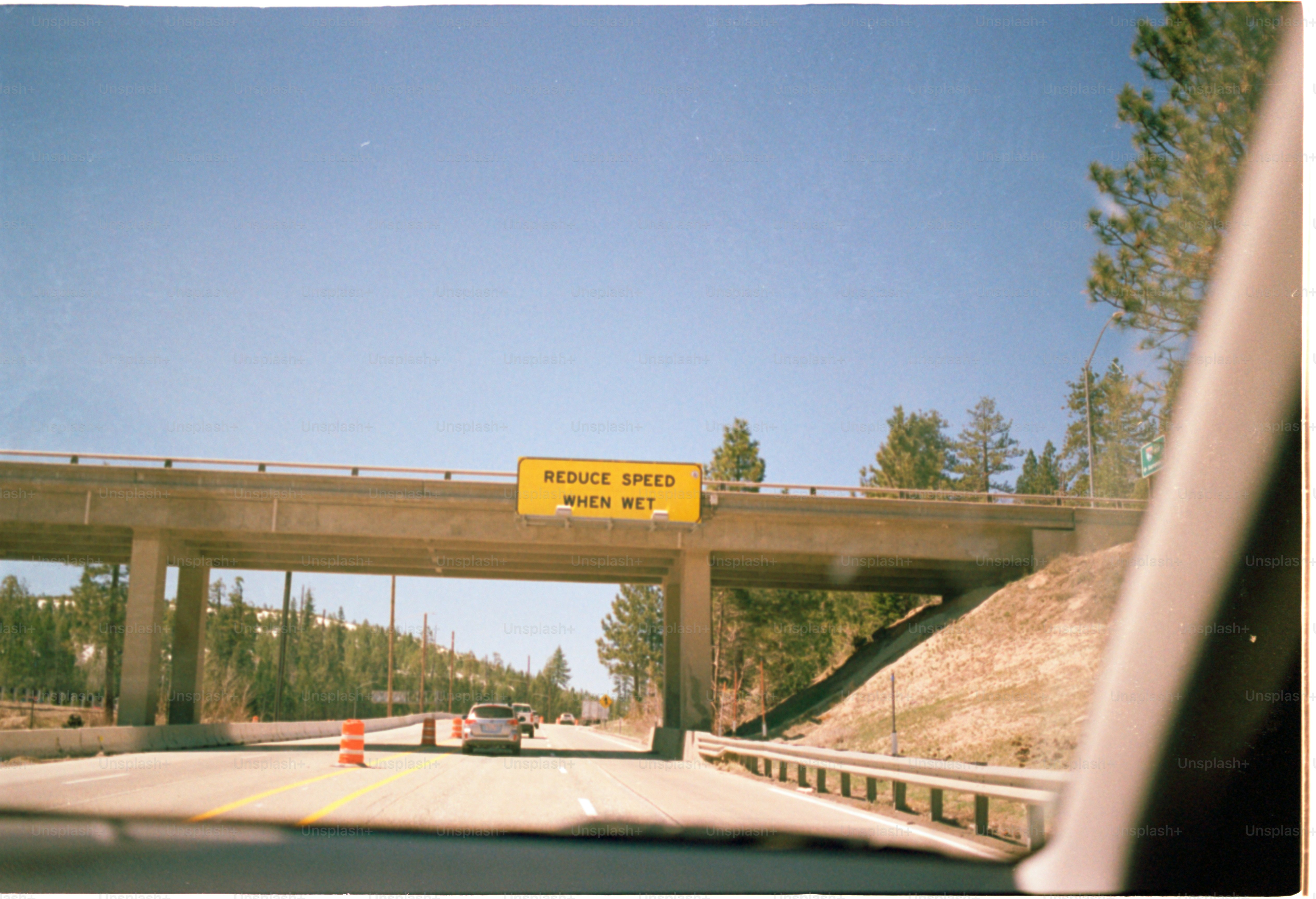 Driving under a bridge with a speed warning sign.