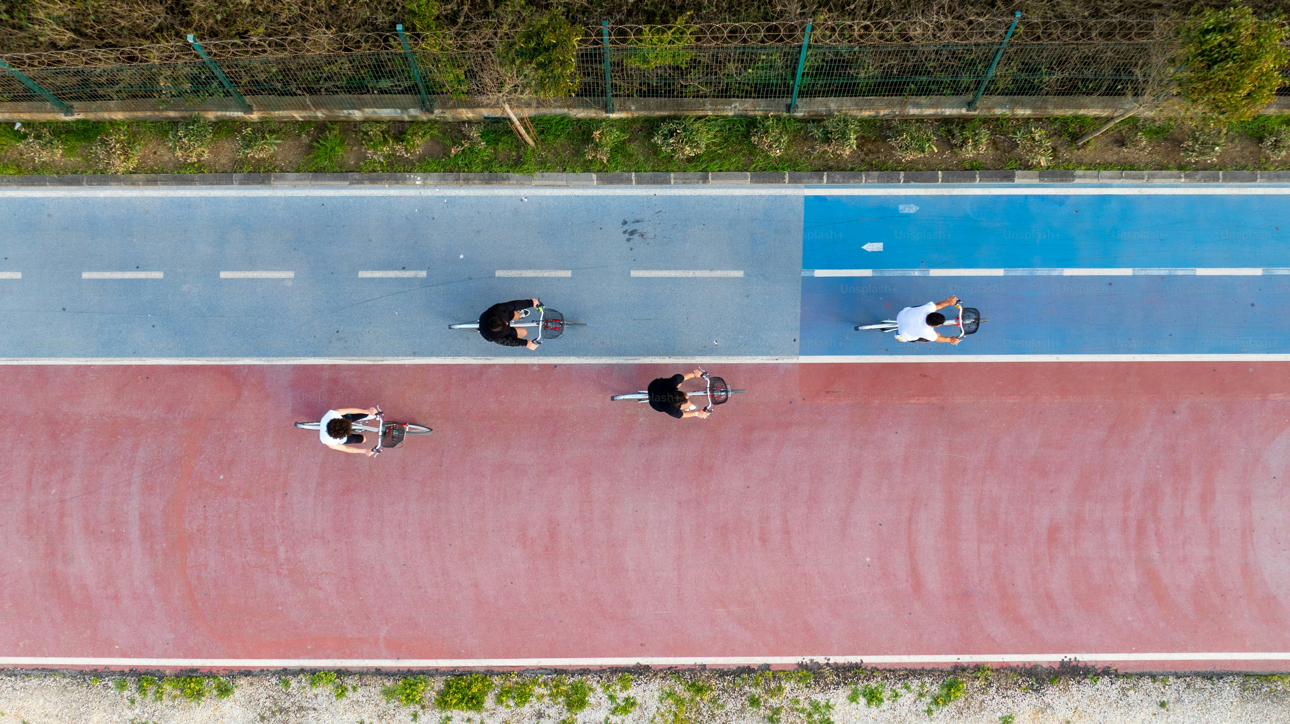 Bicyclists ride on a colorful path.
