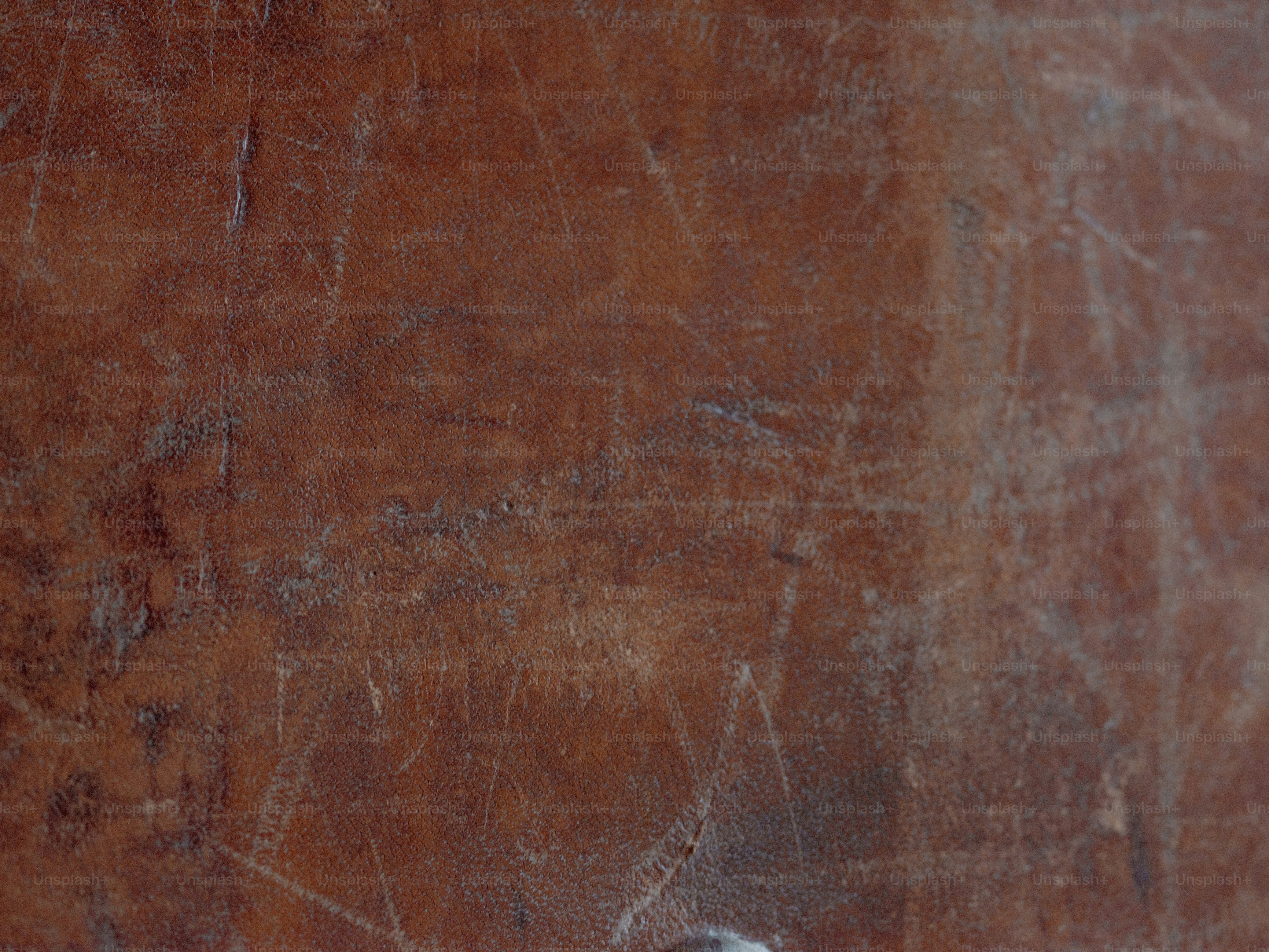 Scratched and worn brown surface, possibly leather.