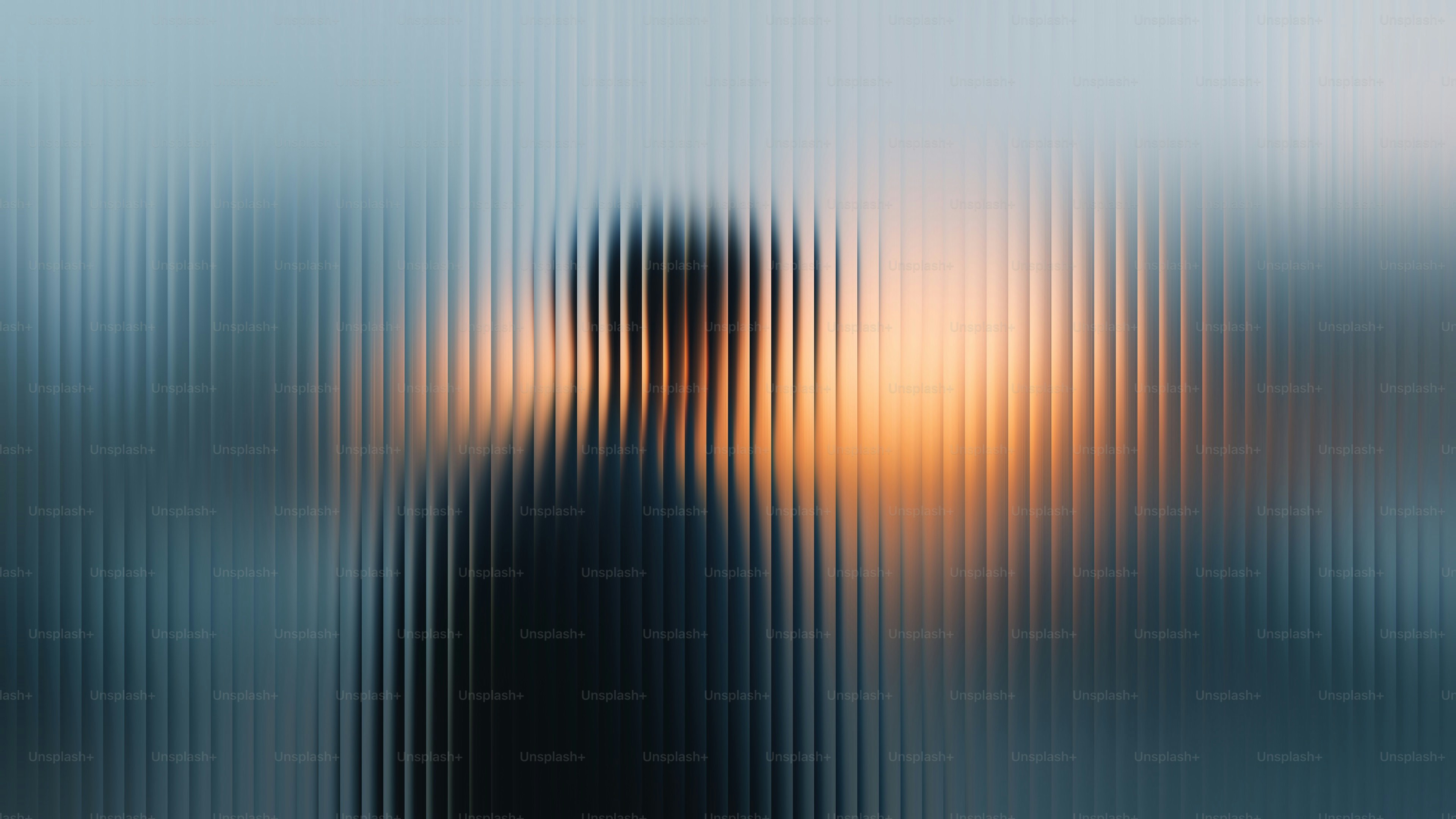 Una persona si staglia dietro un vetro strutturato.