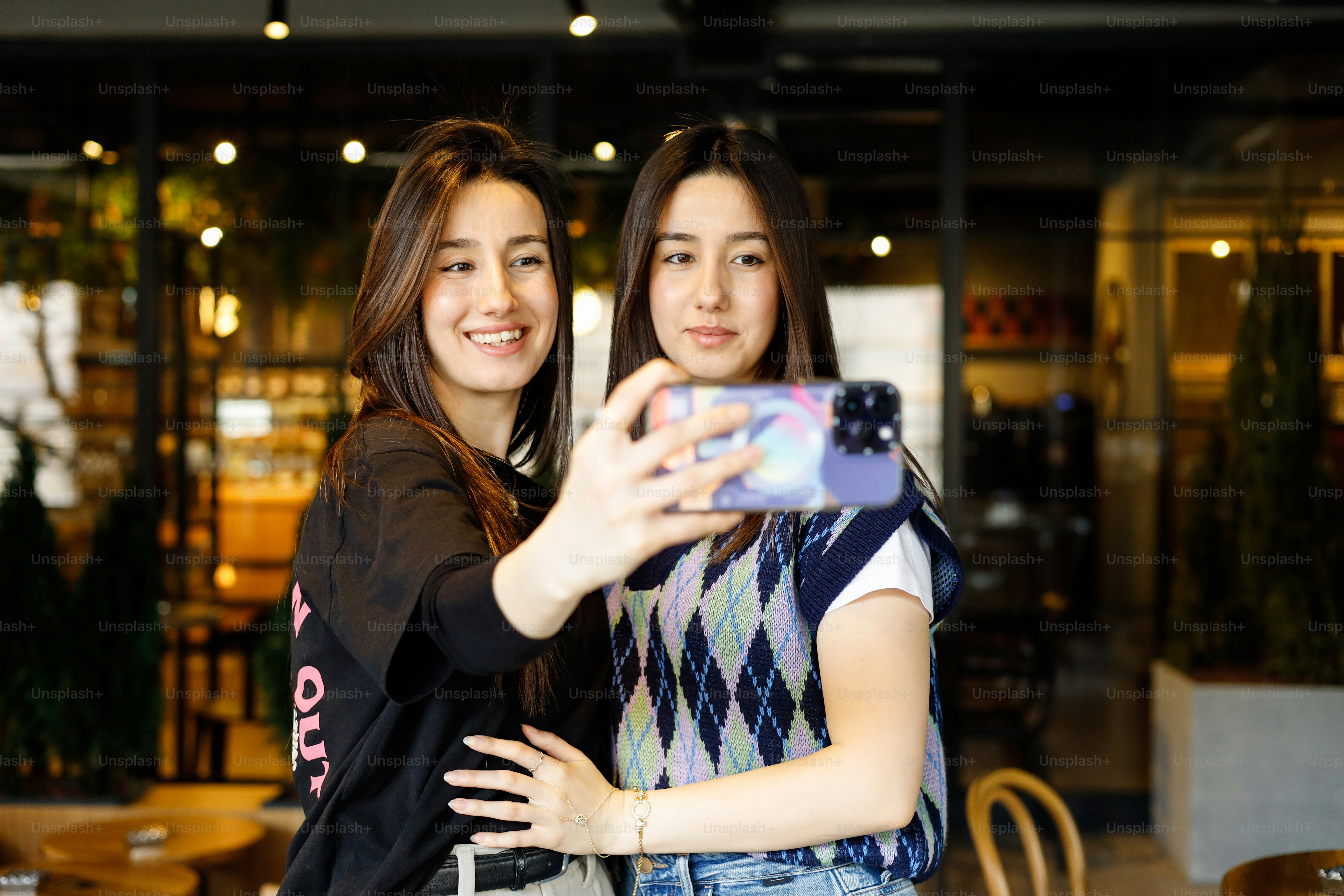 Duas jovens mulheres tiram uma selfie juntas.