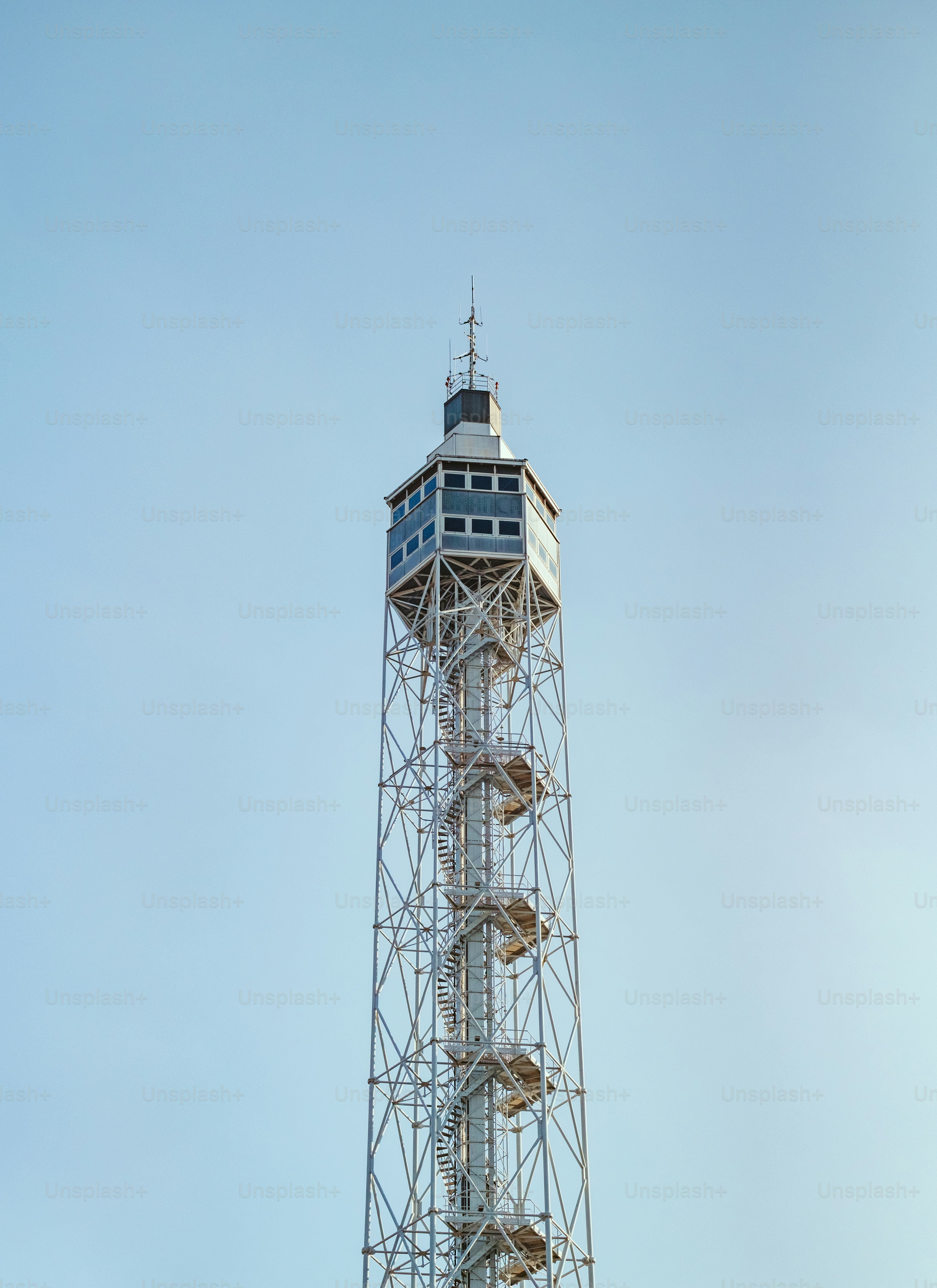 Here's a caption: tall metal tower against a clear, blue sky.