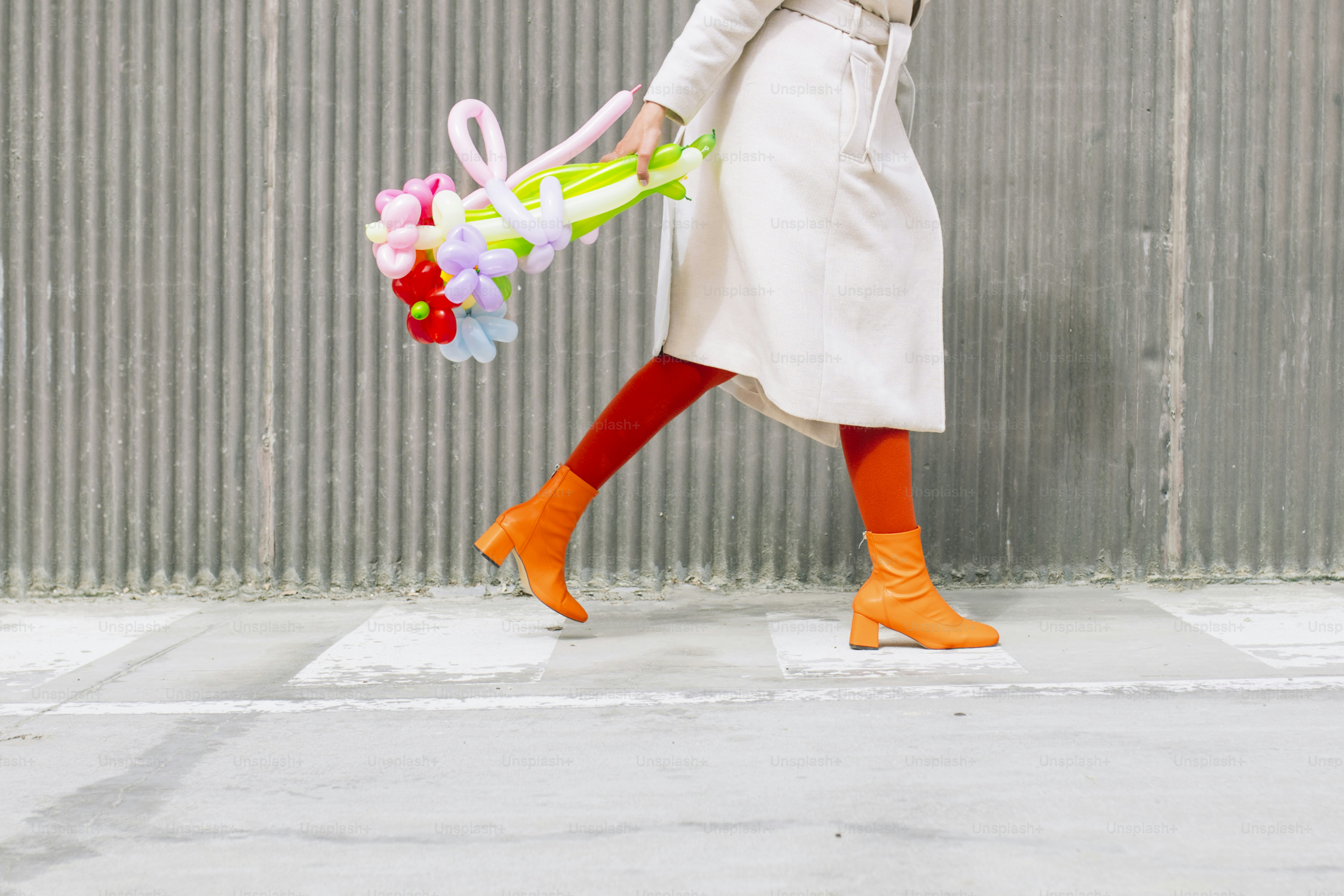 La mujer camina con un ramo de globos de colores.
