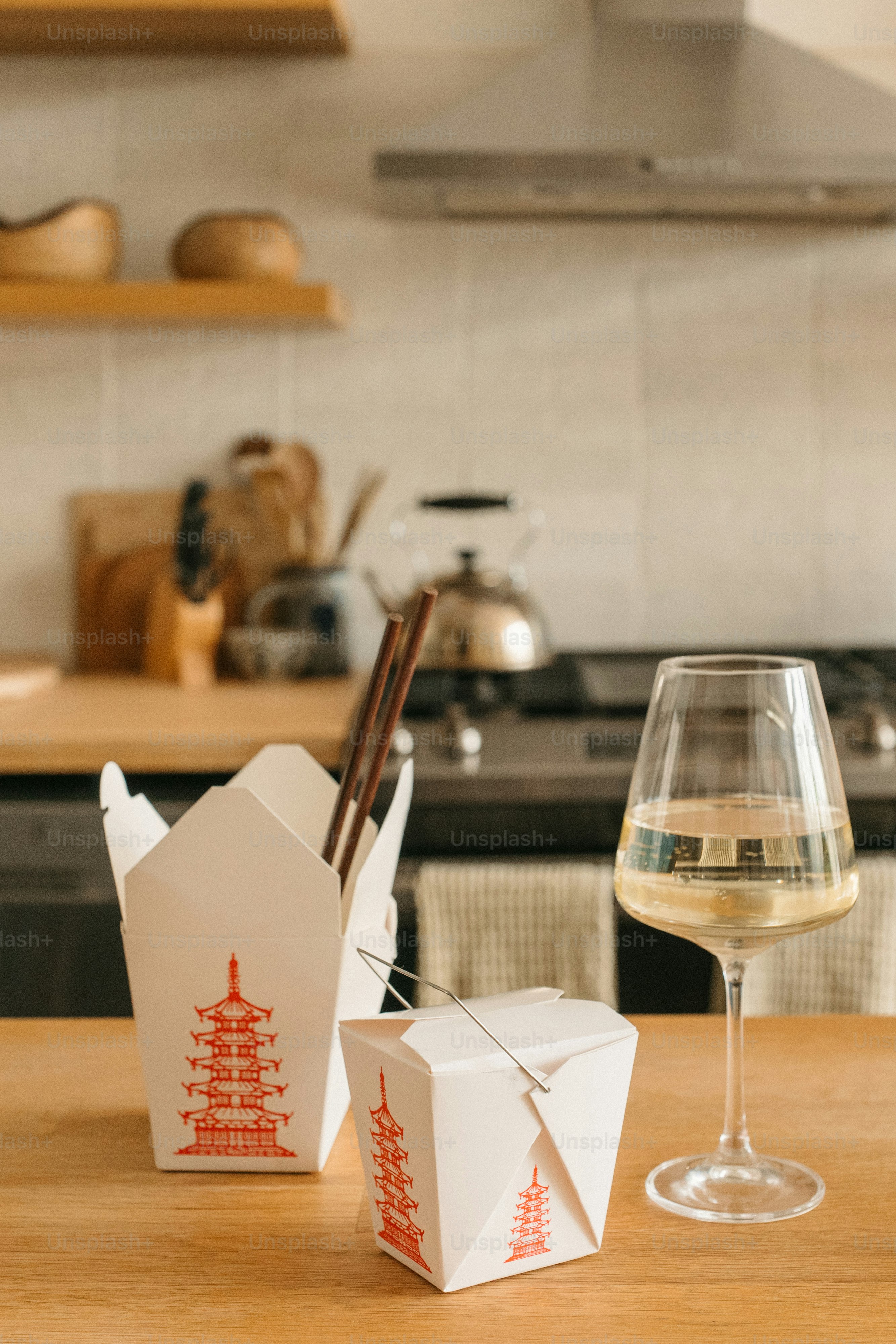 Takeout food and wine sit on a kitchen counter.