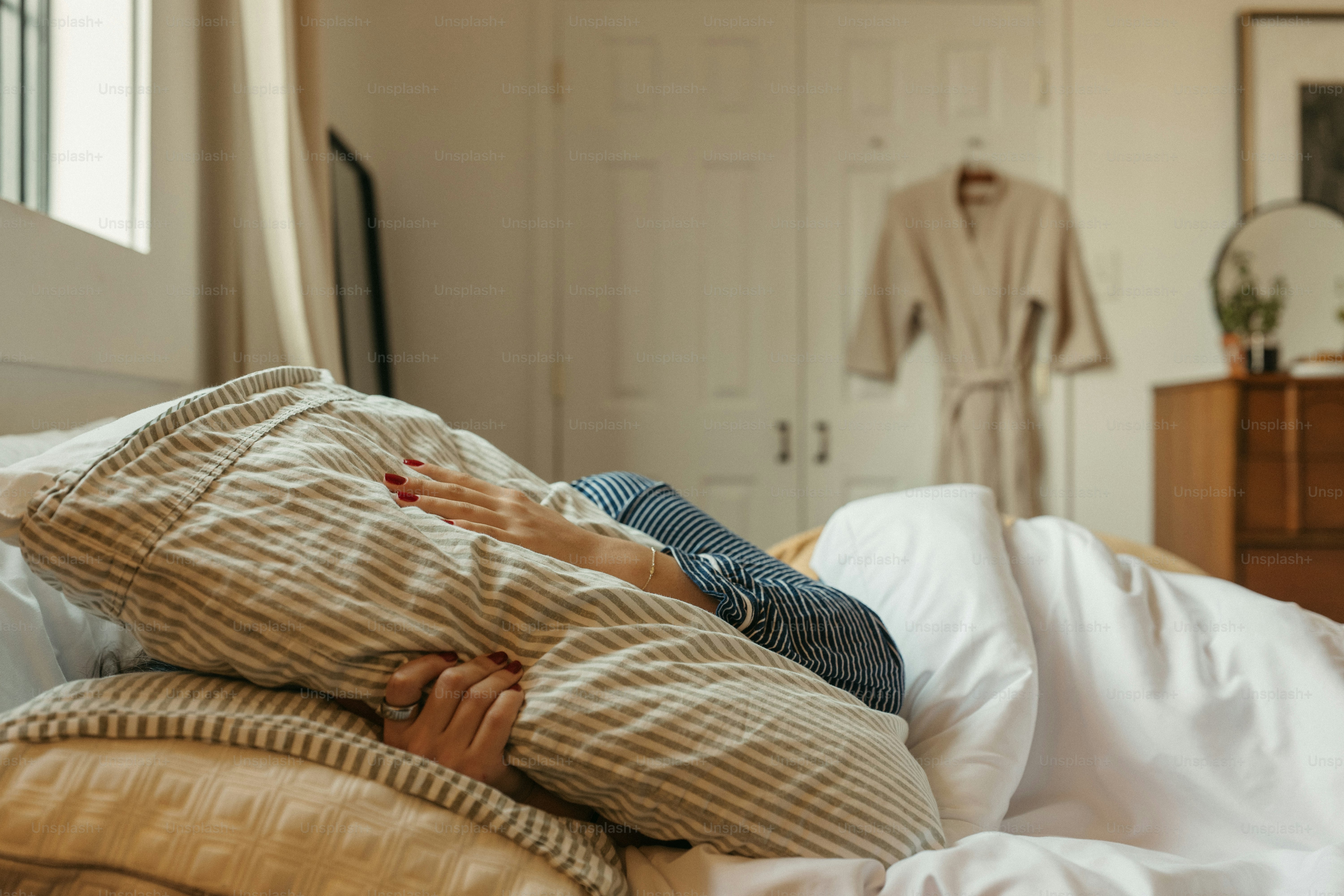 Someone is covering their face with a pillow.