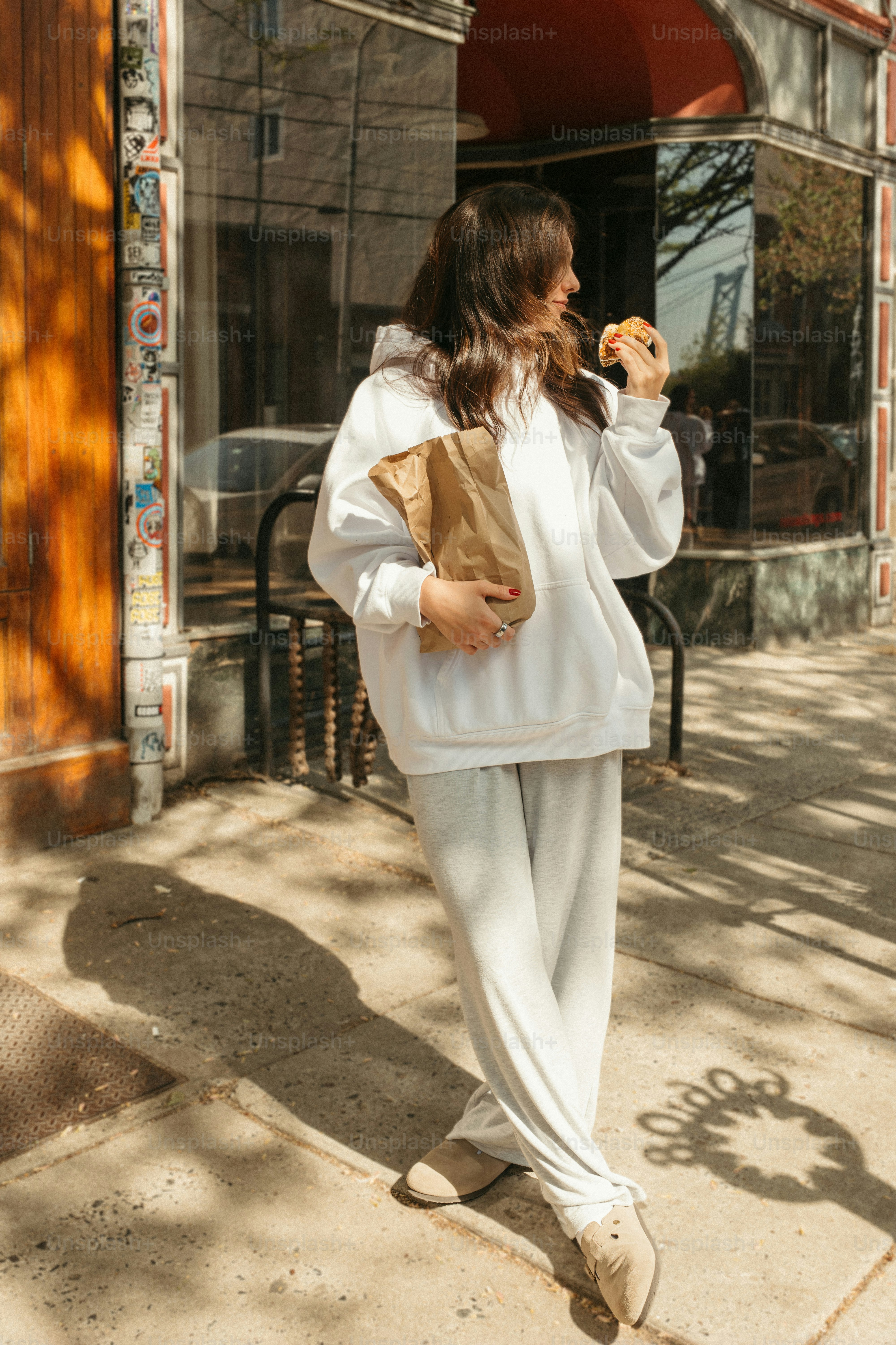 Woman enjoys a burger outside on a sunny day.