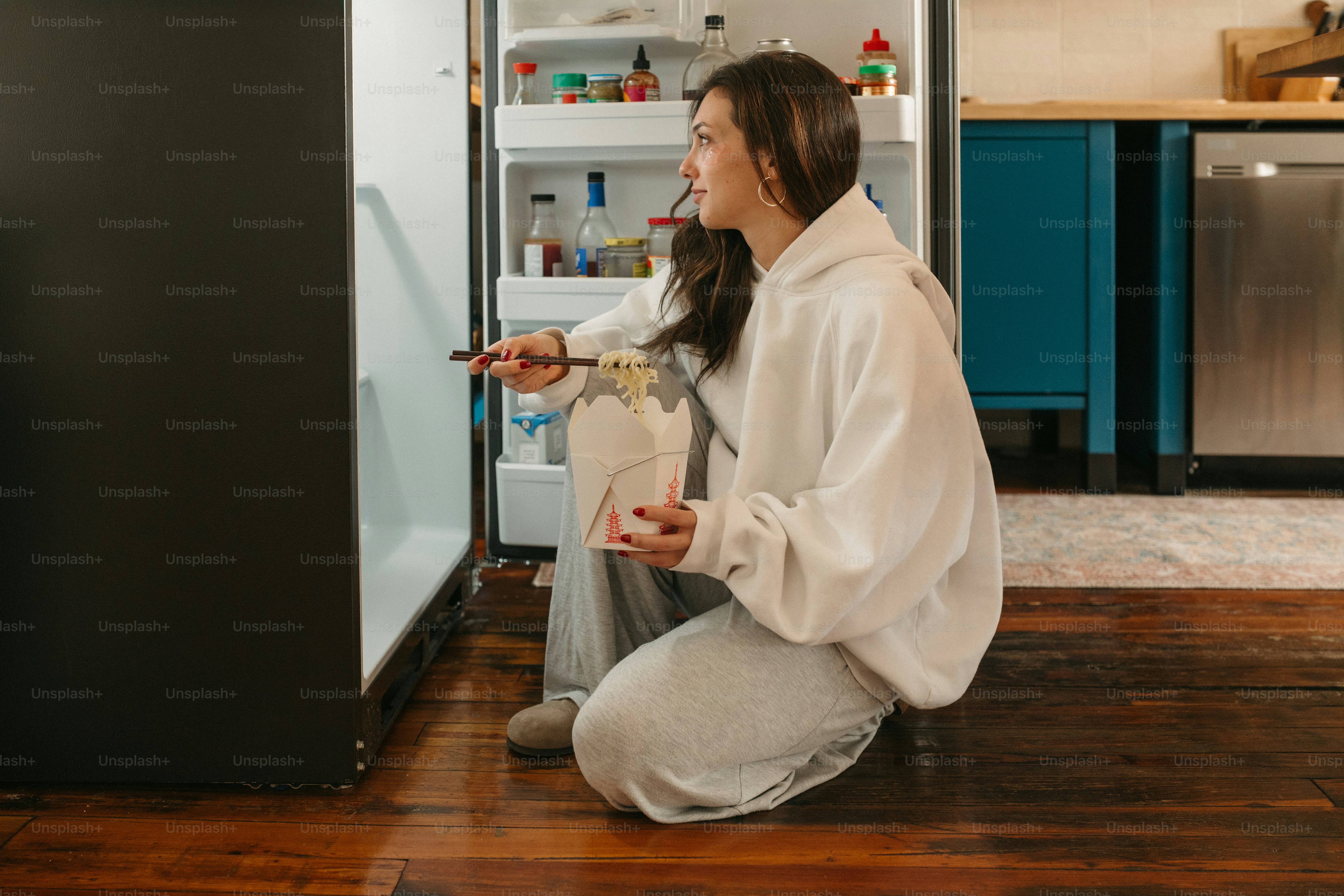 A woman checks inside a fridge.