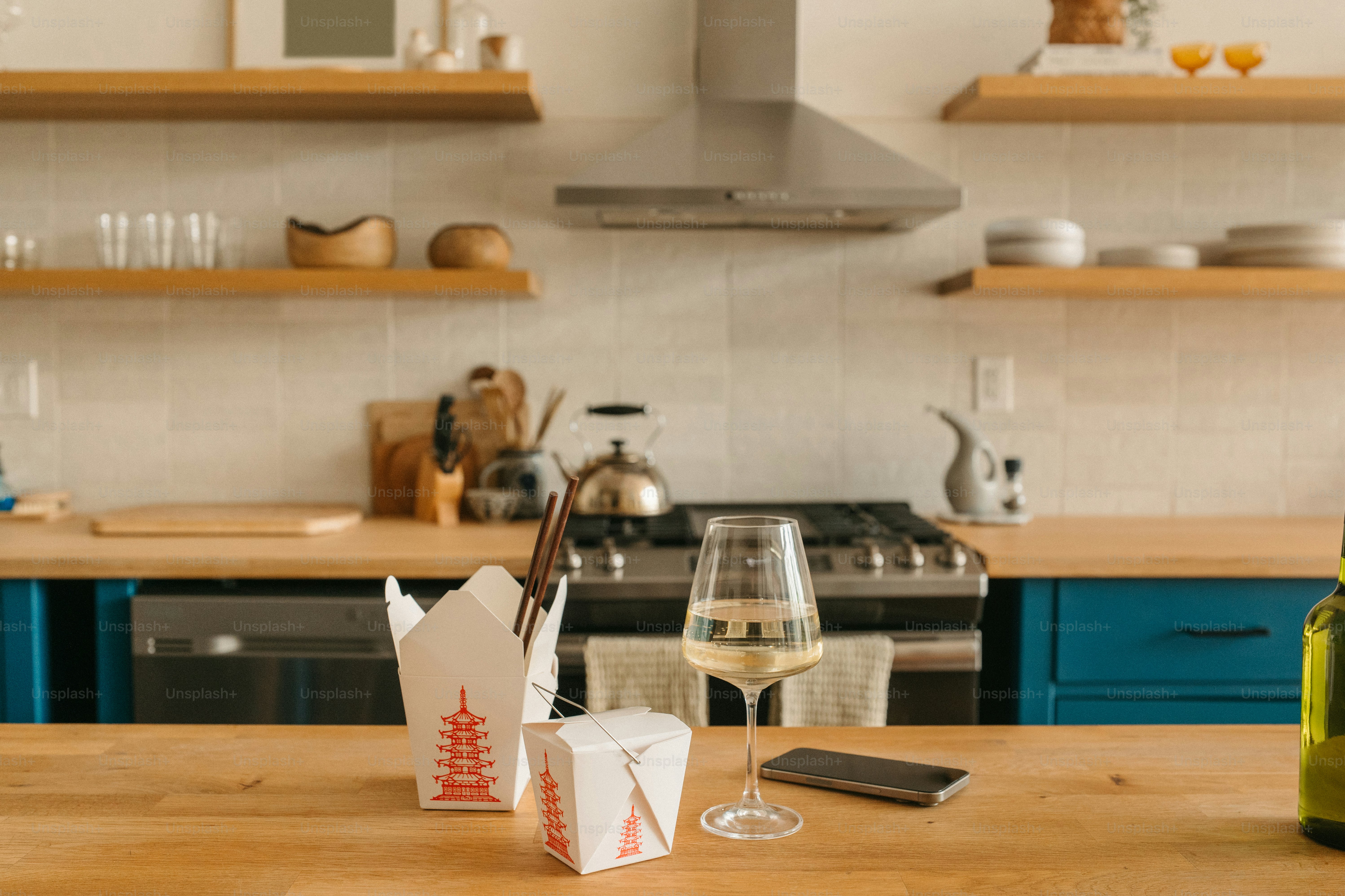 Takeout and wine on a kitchen counter.