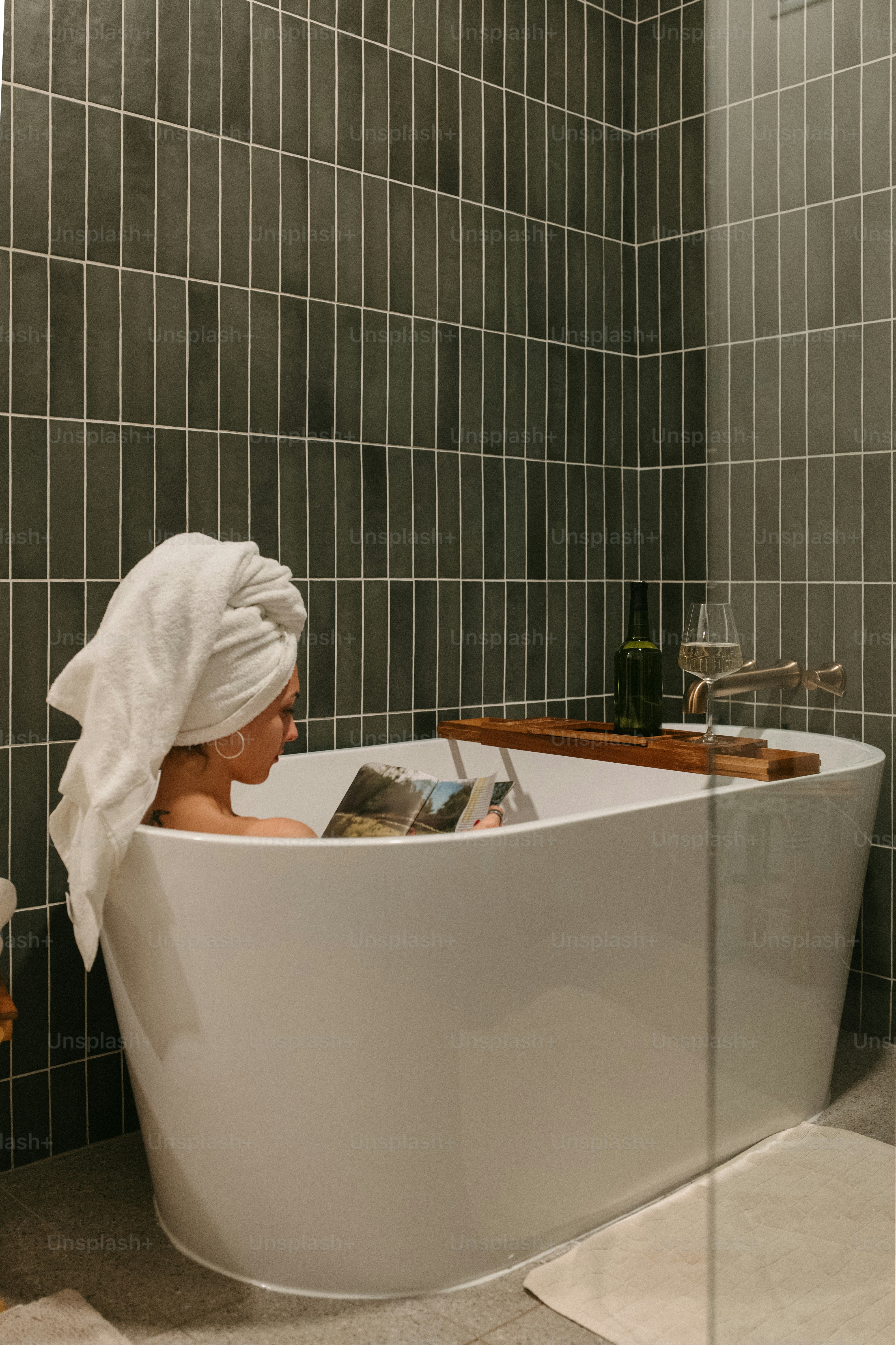 Woman relaxes in a tub with a towel.