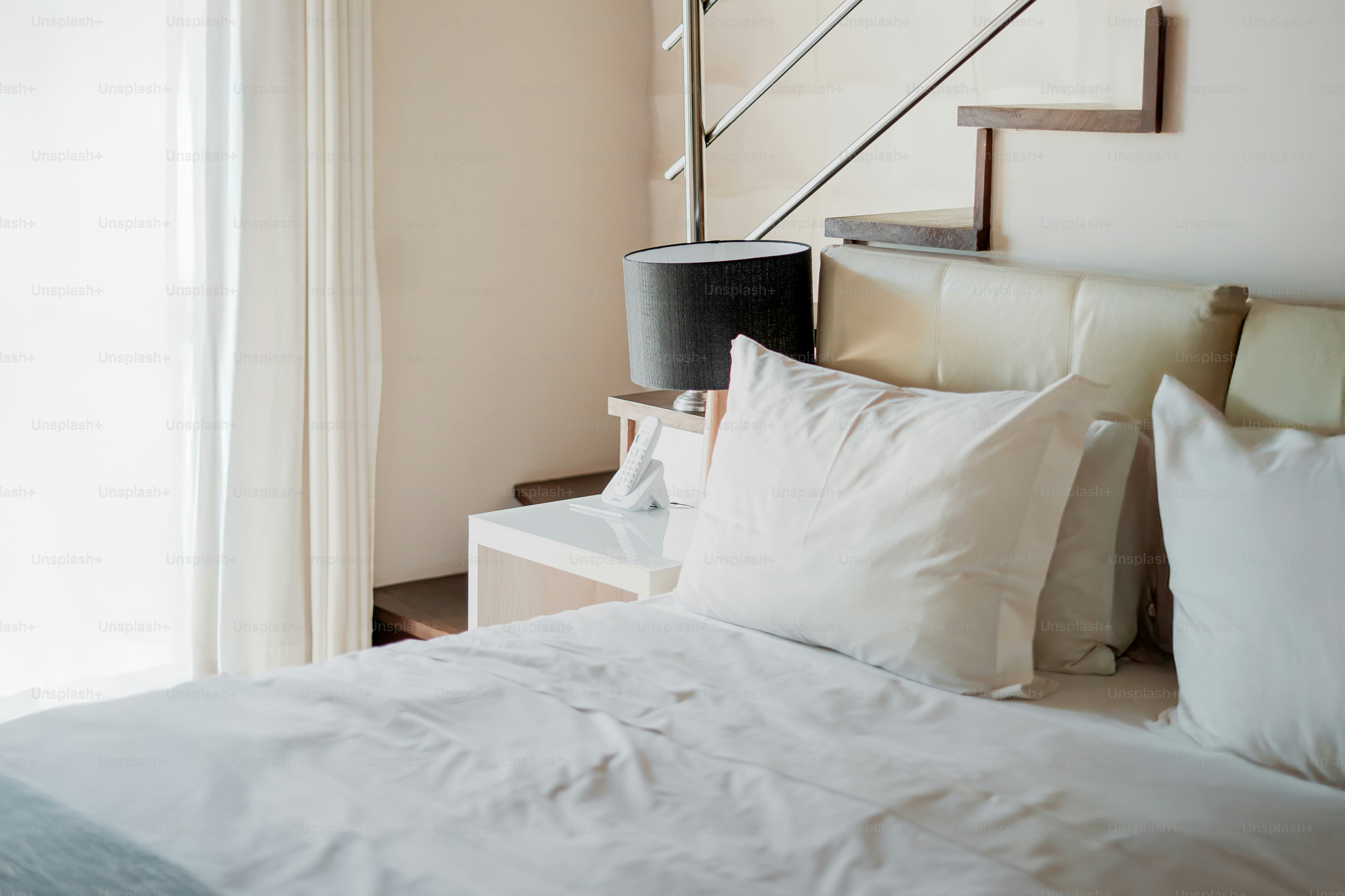 A comfortable bed with pillows and a nightstand.