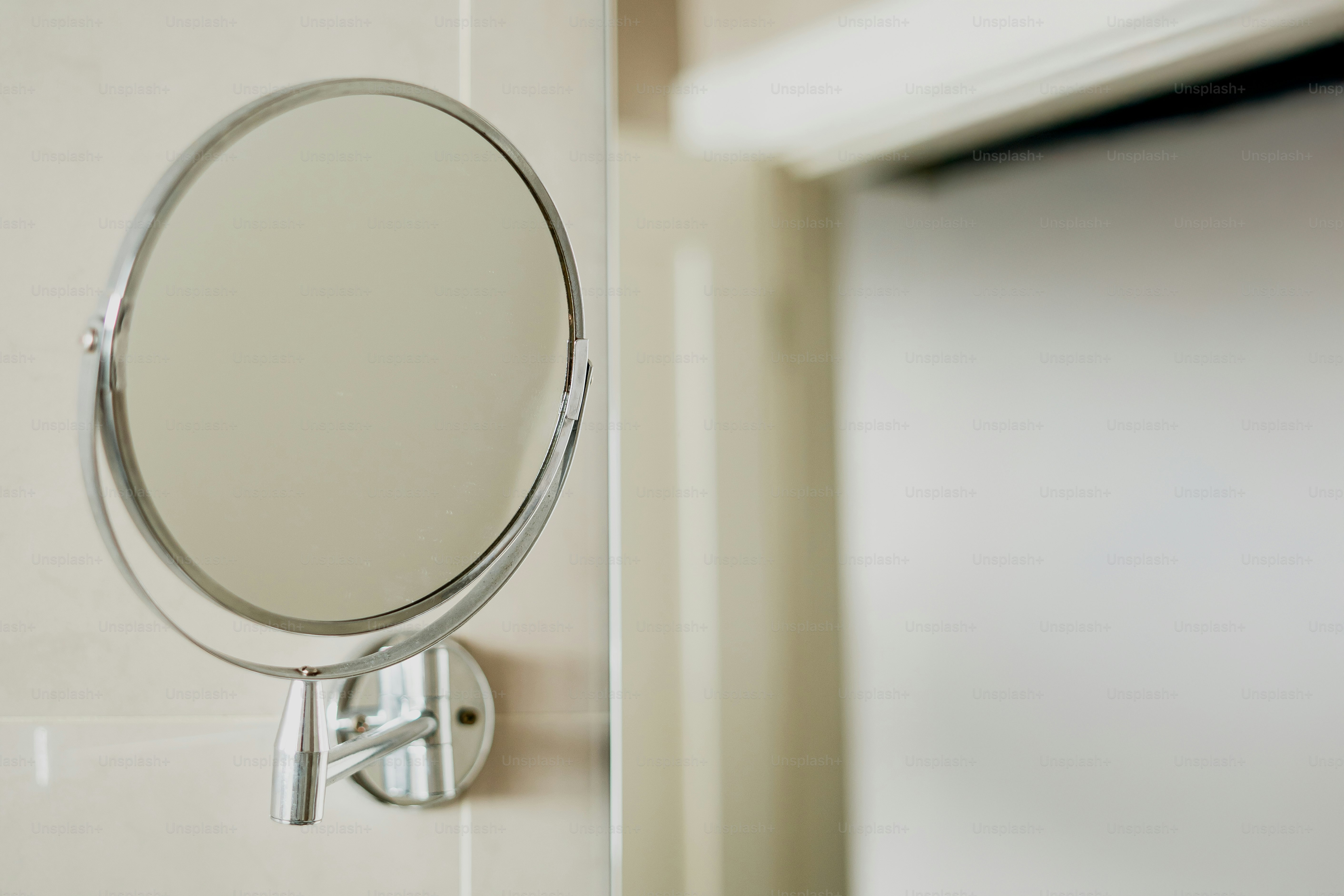 A magnifying mirror hangs on a wall.