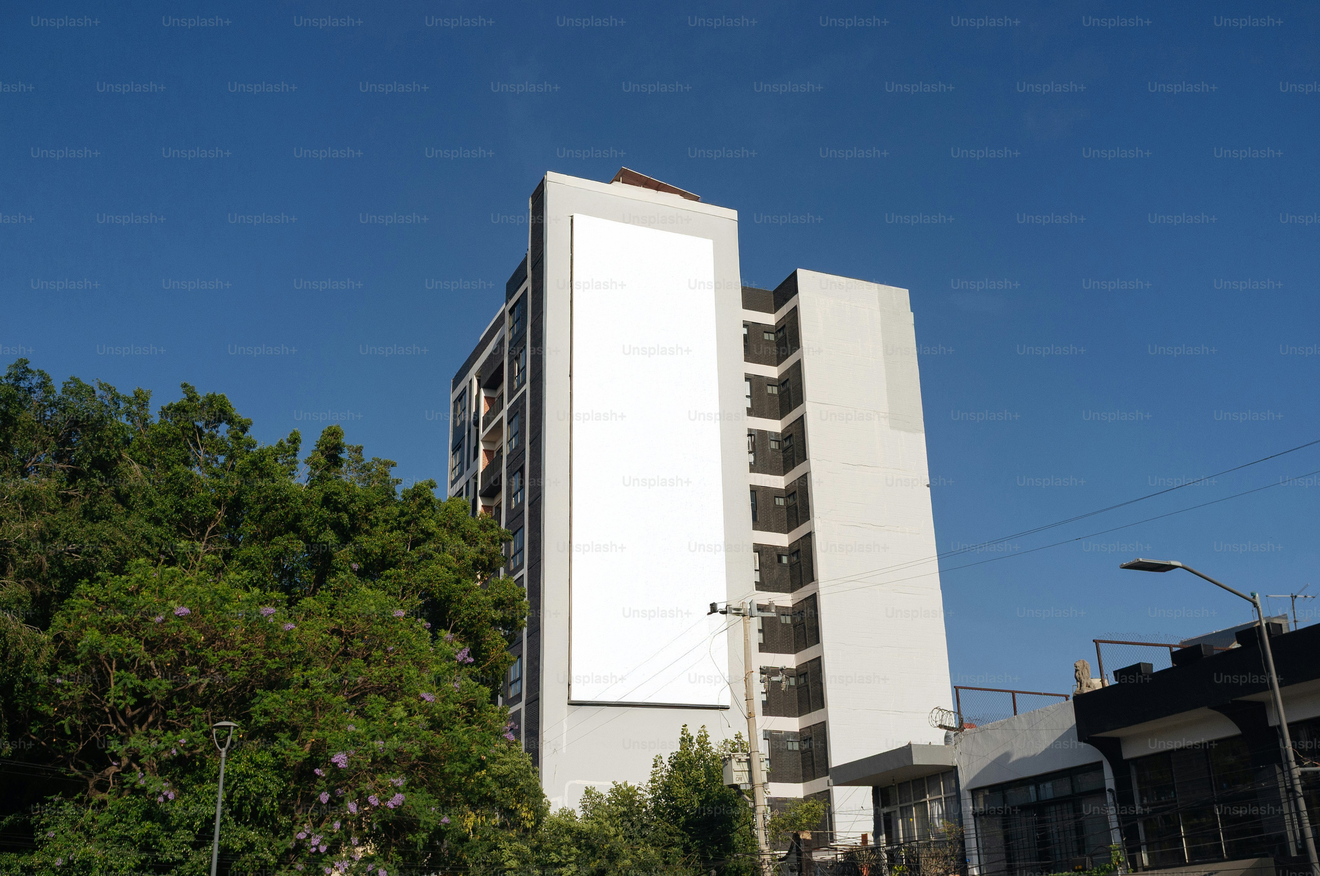 Un grand bâtiment avec un panneau d’affichage blanc vierge.