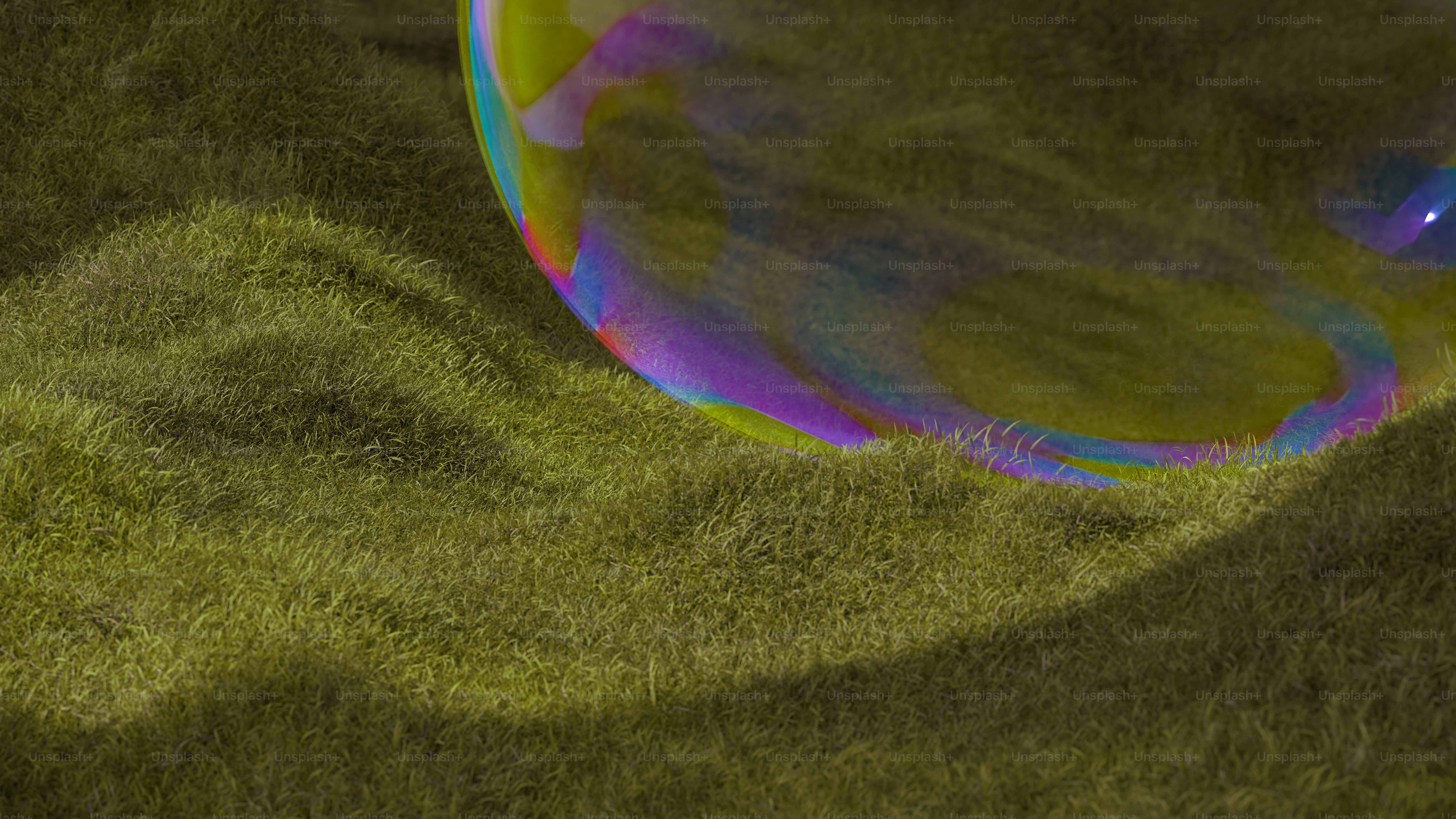 A colorful bubble rests on green grass.