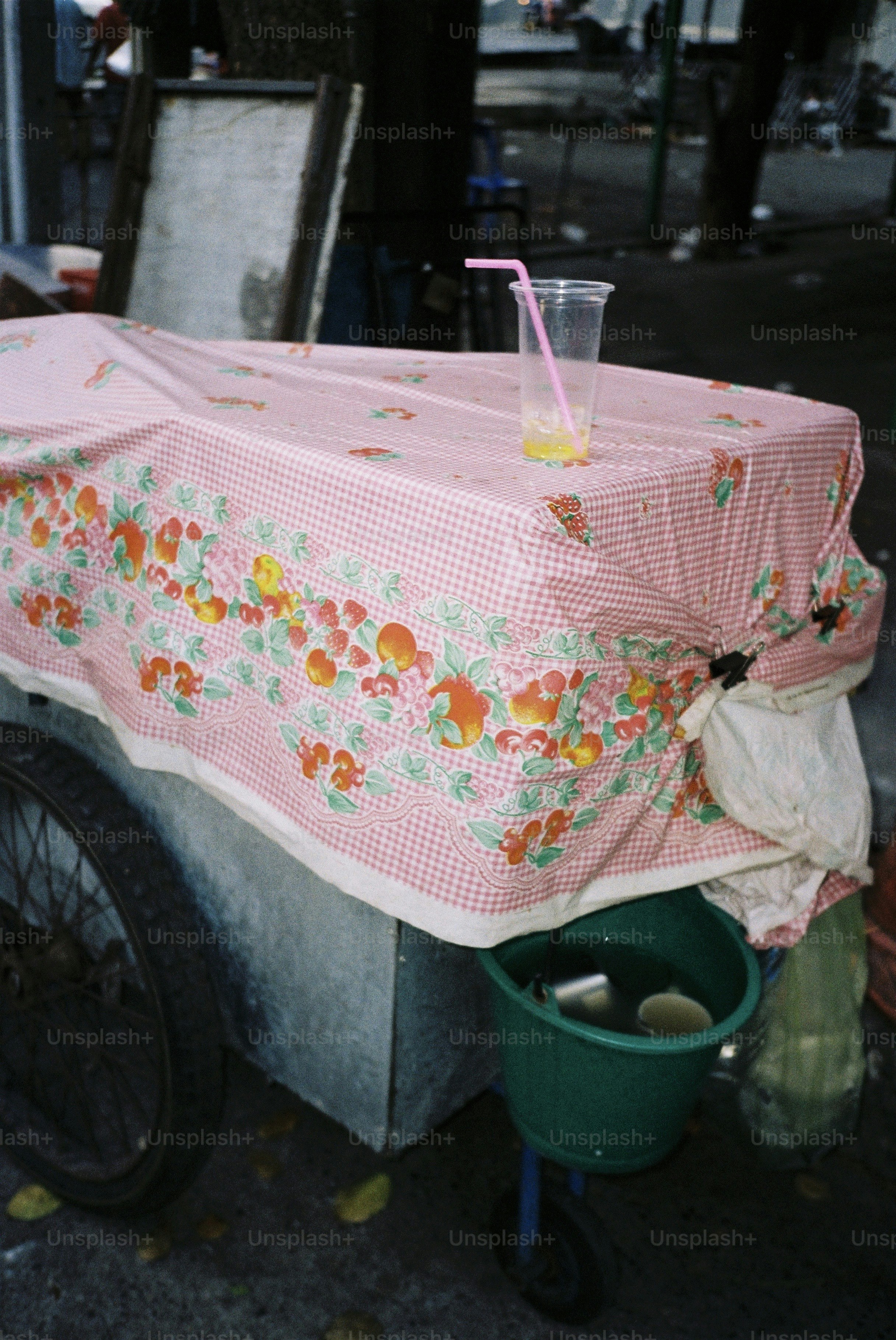 A juice cart sits on a city street.